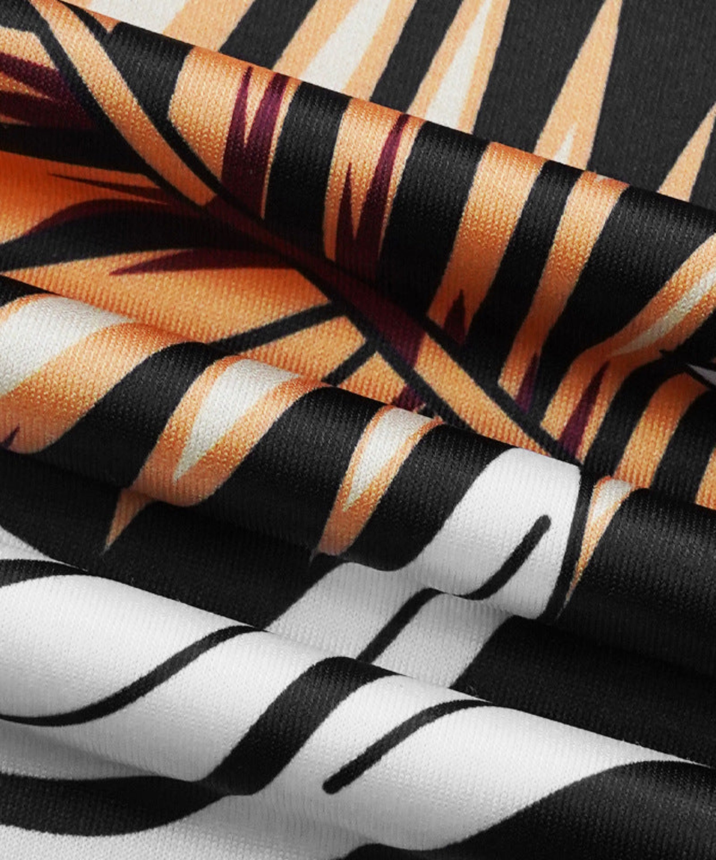 Close-up of fabric with tiger stripe pattern in black, orange, and white.