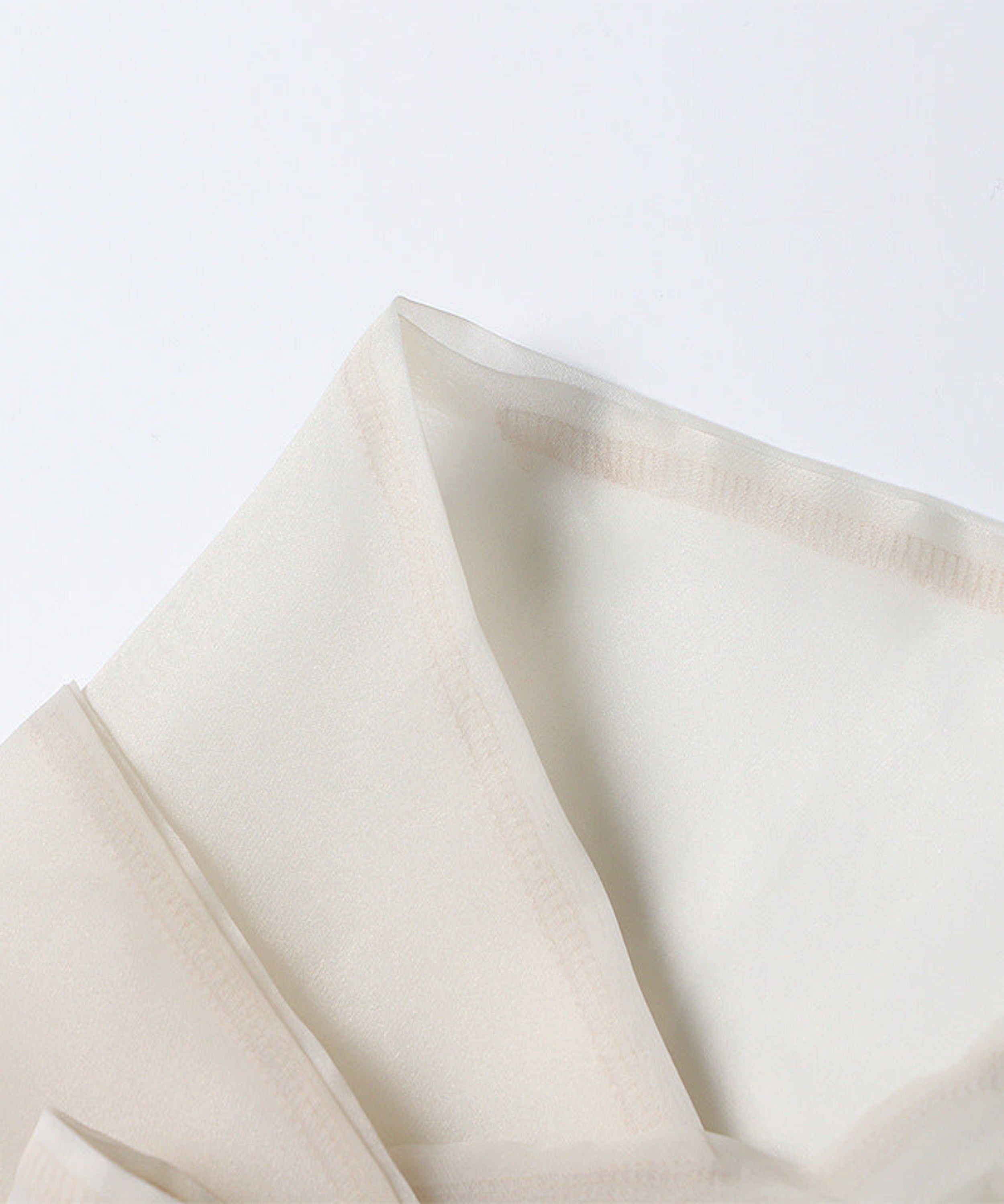 Close-up of beige fabric on a light gray background