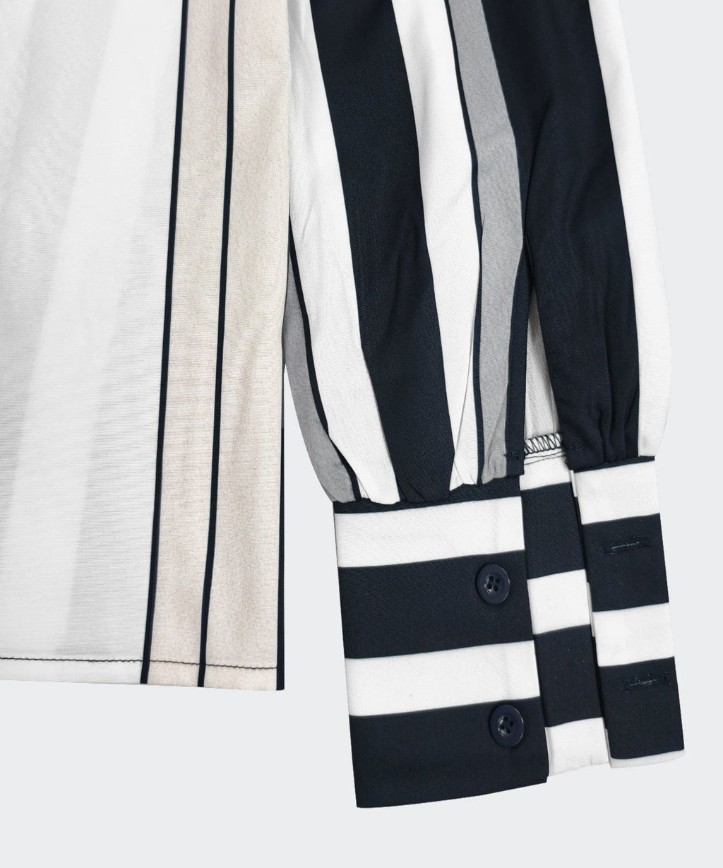 Close-up of a black and white striped garment with buttons on a light gray background