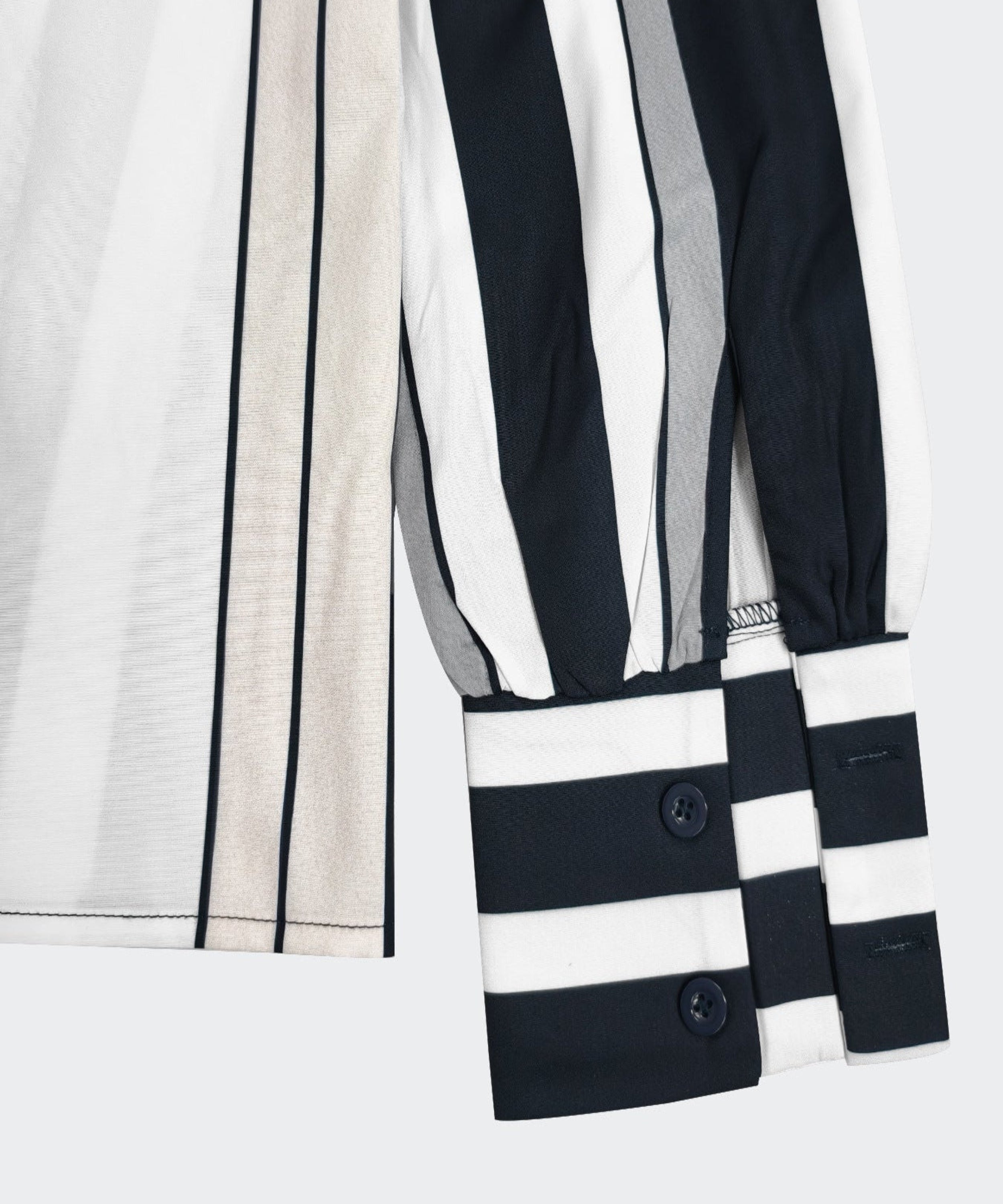 Close-up of a black and white striped garment with buttons on a light gray background