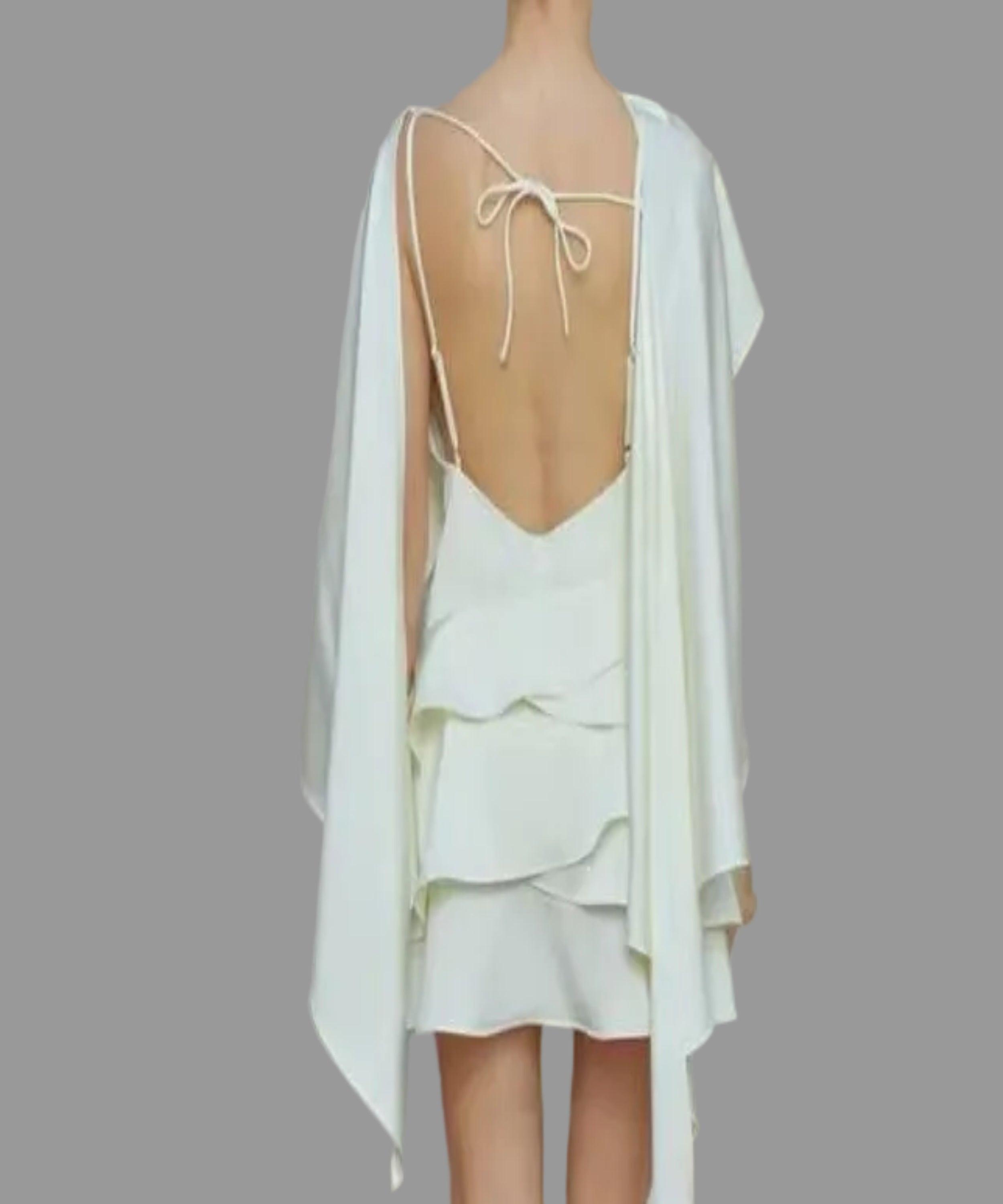 Woman wearing a white dress with a cape, shown from front and back, against a neutral background.