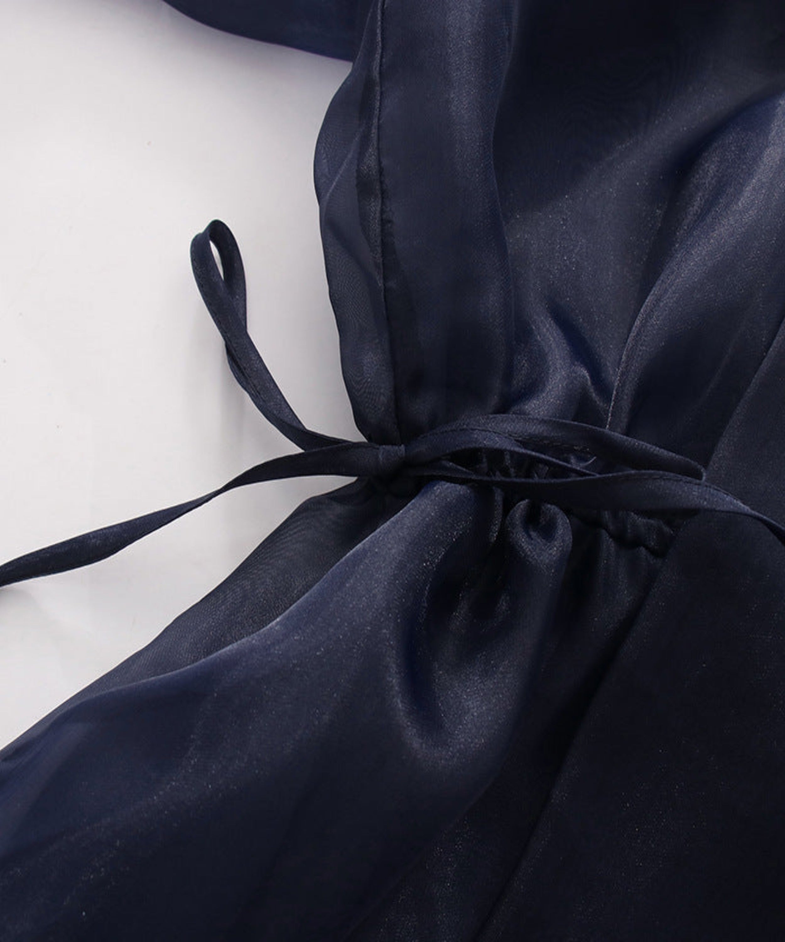 Navy blue satin fabric with a bow on a white background