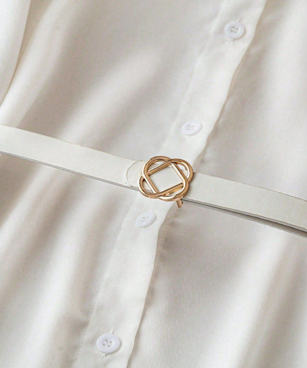 White shirt with a gold belt buckle on a plain background