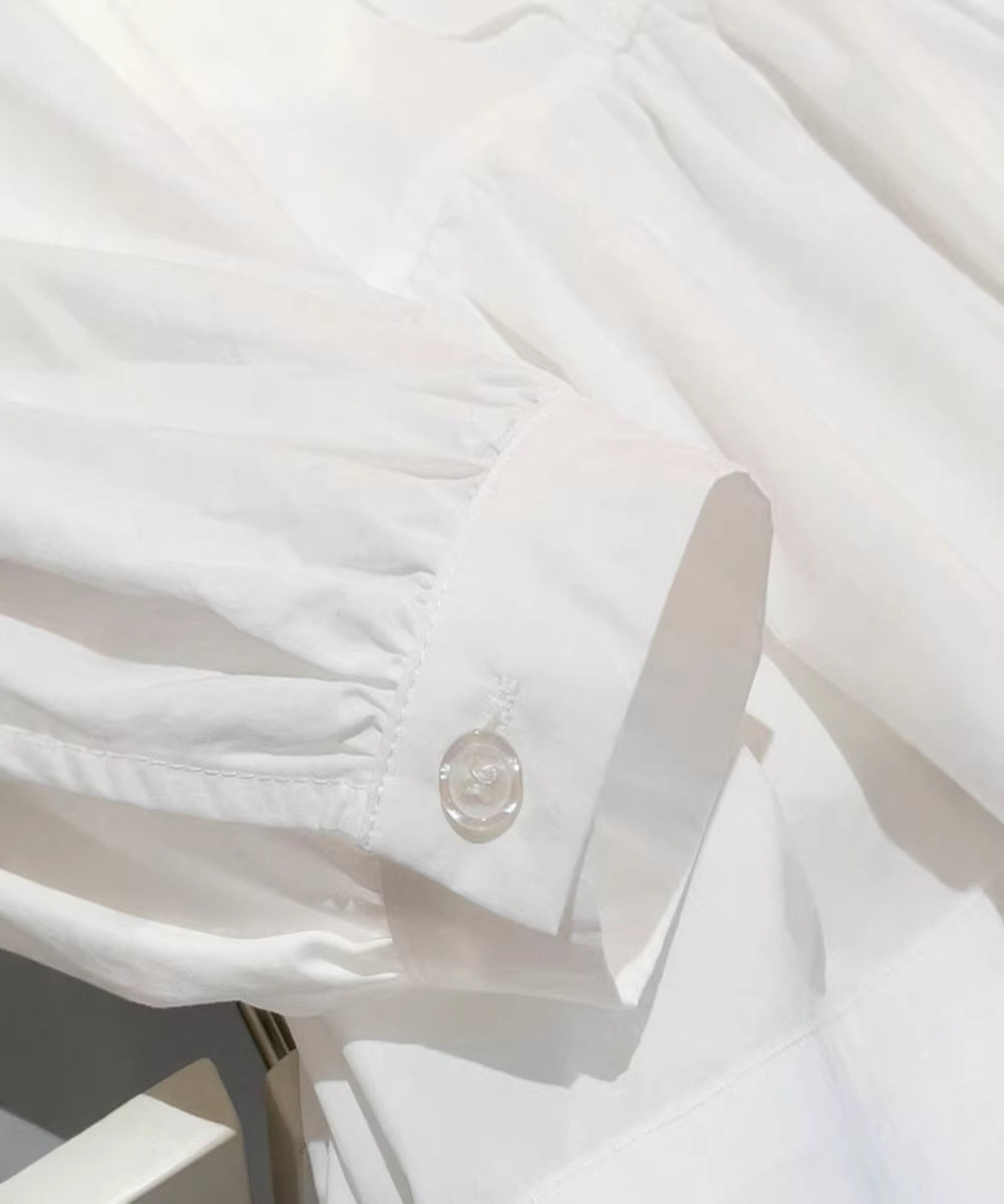 Close-up of a white shirt with a button and cuff