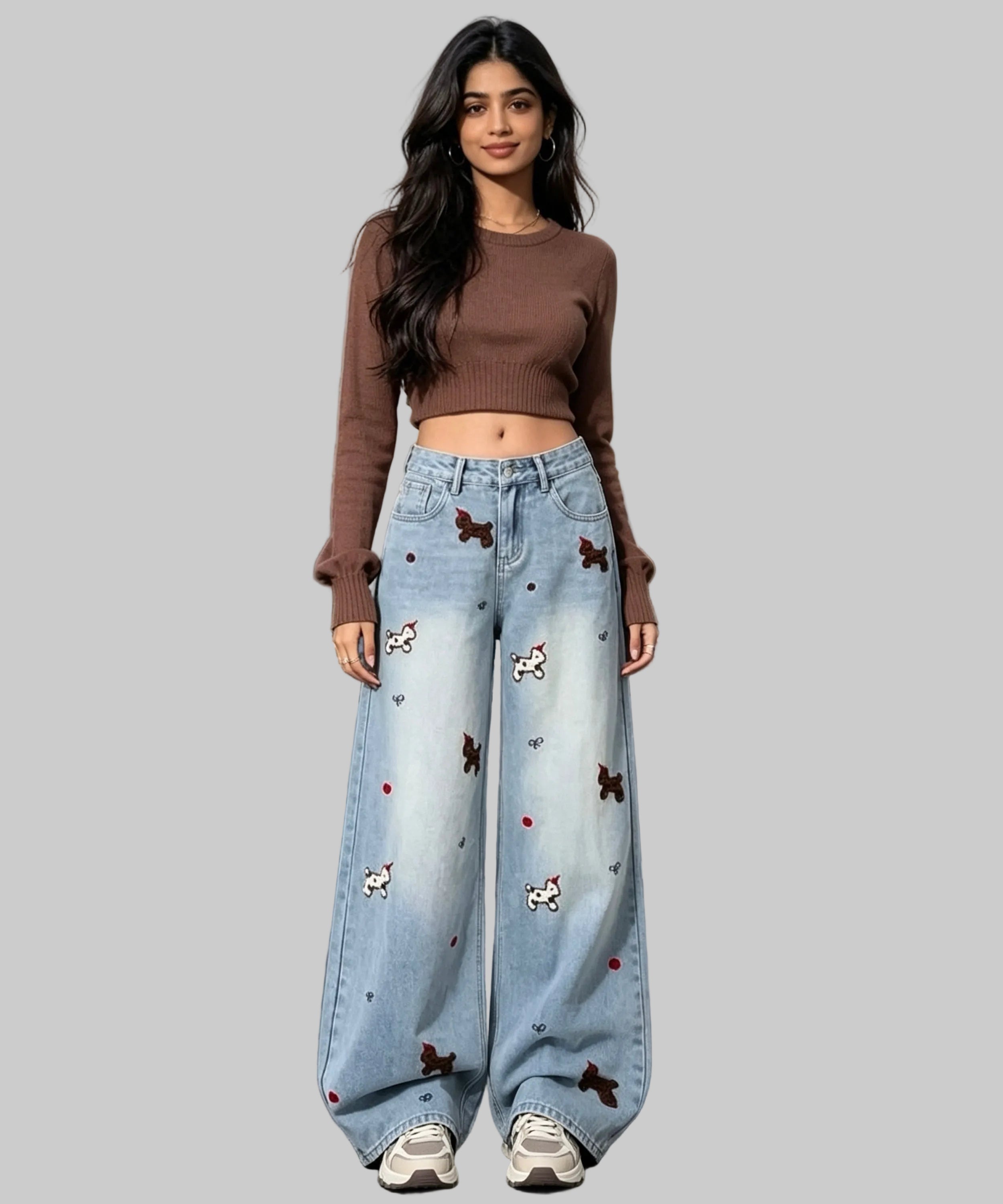 Woman in brown top and light blue jeans with animal prints on  a white background.