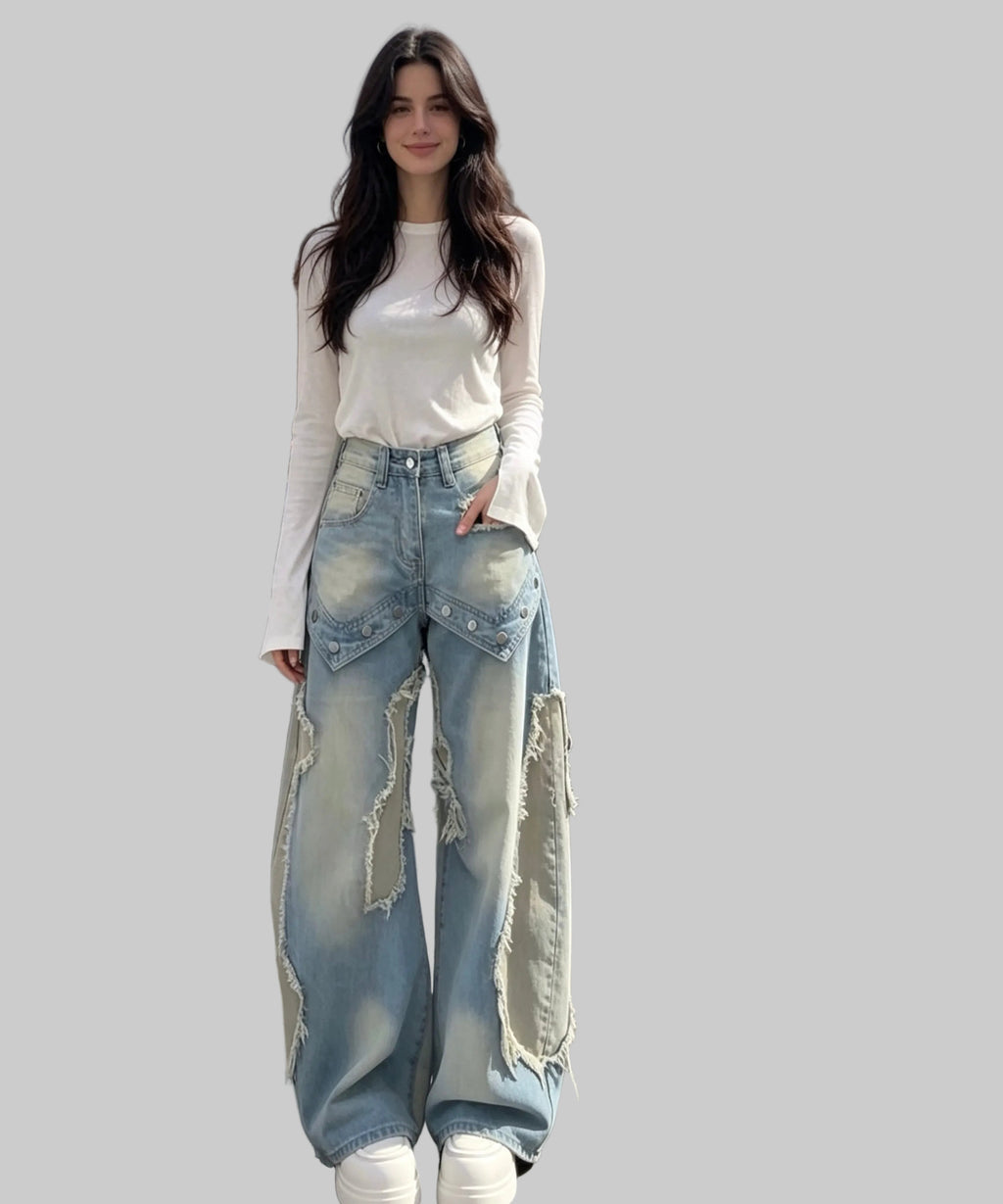 Woman wearing a white top and ripped blue jeans on a white background.