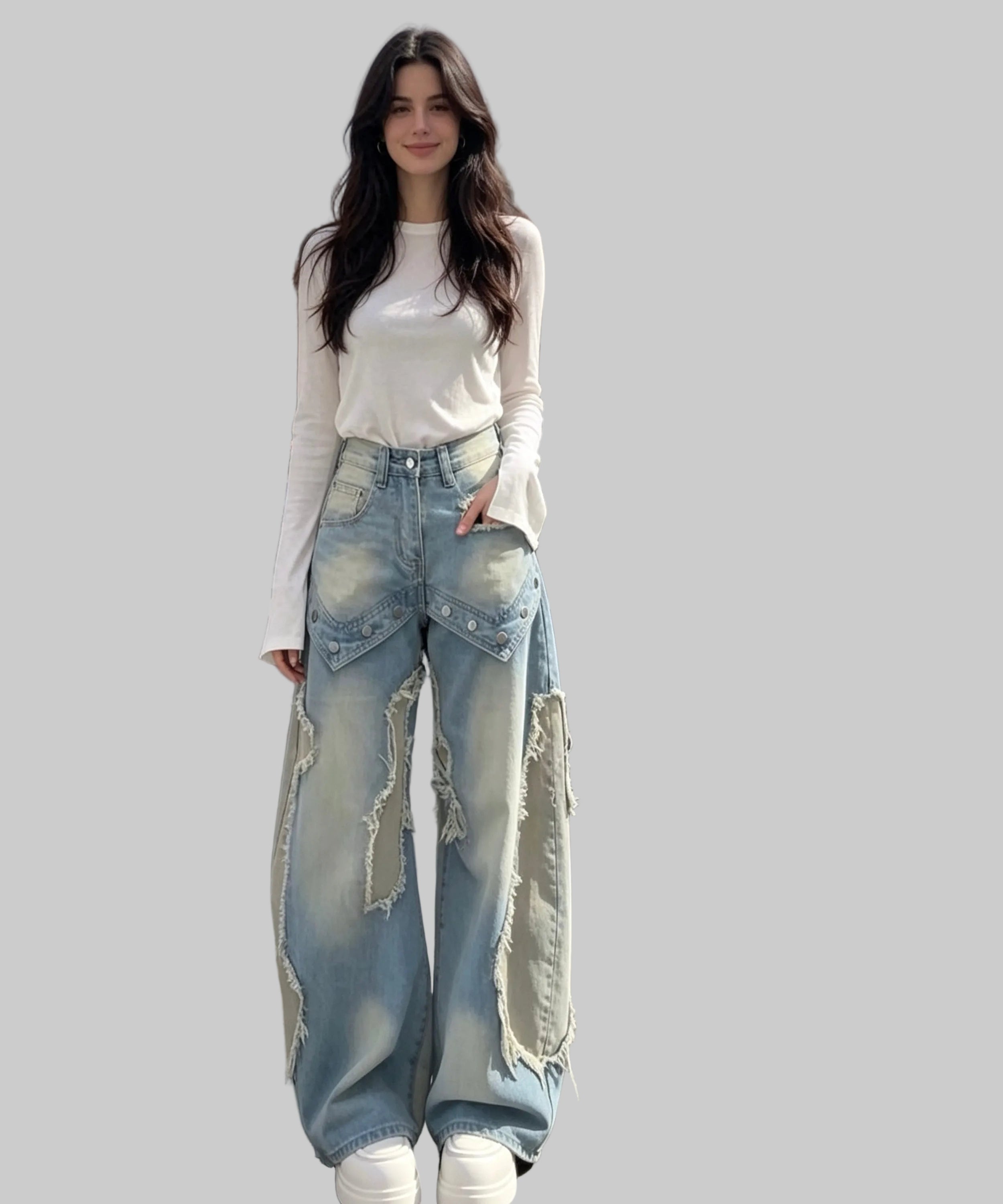 Woman wearing a white top and ripped blue jeans on a white background.