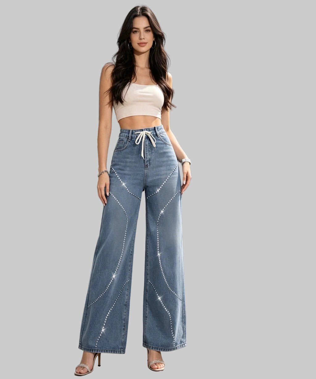 Woman in a white background wearing a white crop top and blue jeans.