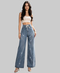 Woman in a white background wearing a white crop top and blue jeans.