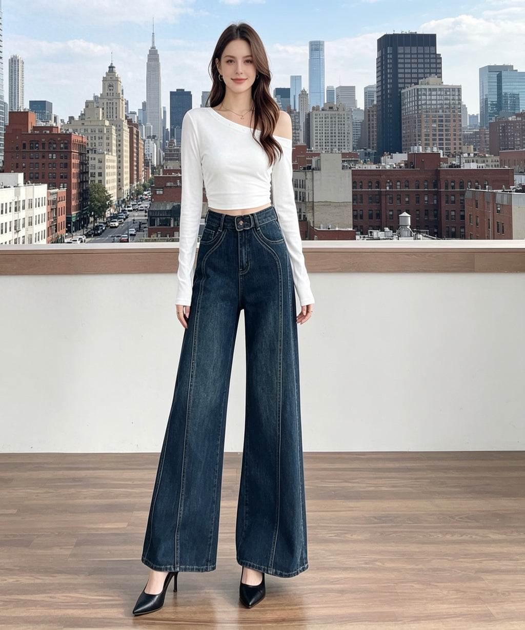 Woman wearing a white top and blue jeans standing in front of a city skyline.