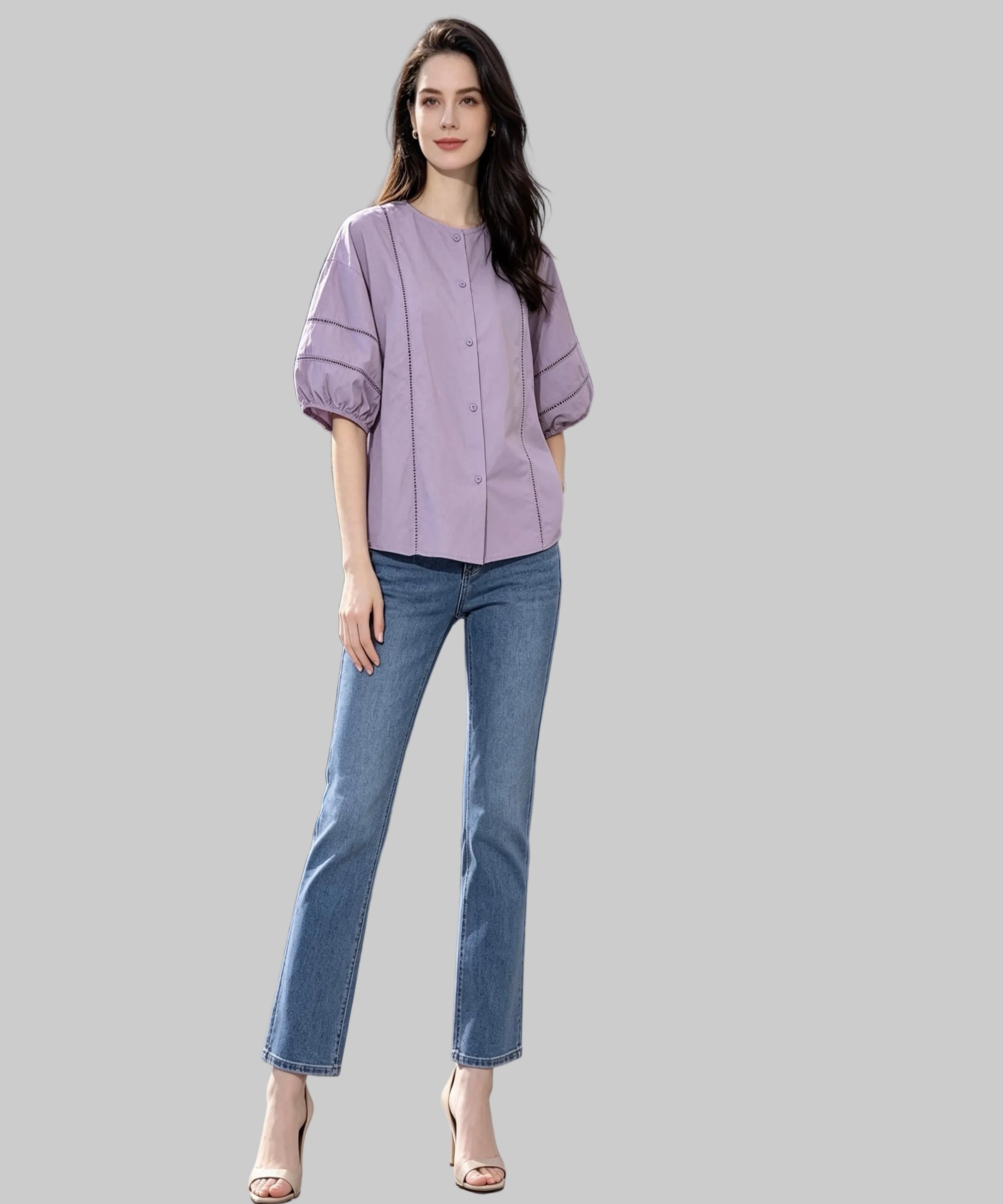 Woman in a lavender blouse and blue jeans standing on a white background.