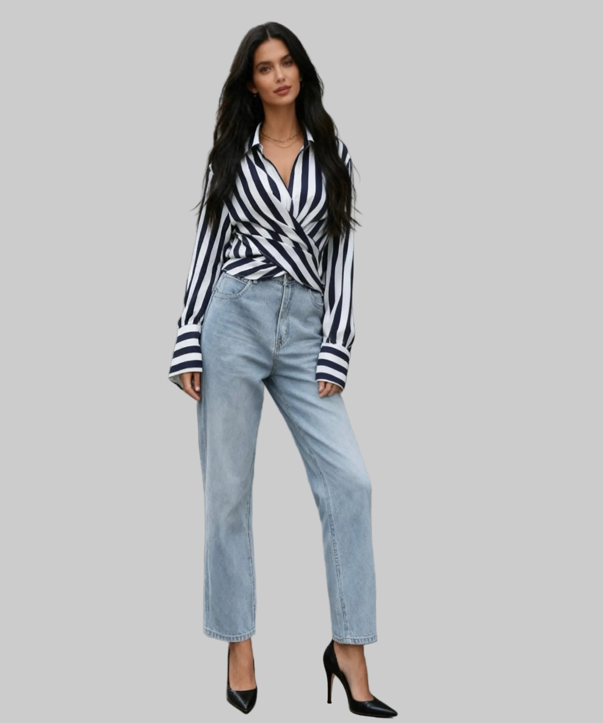 Woman in a striped shirt and jeans standing on white background.