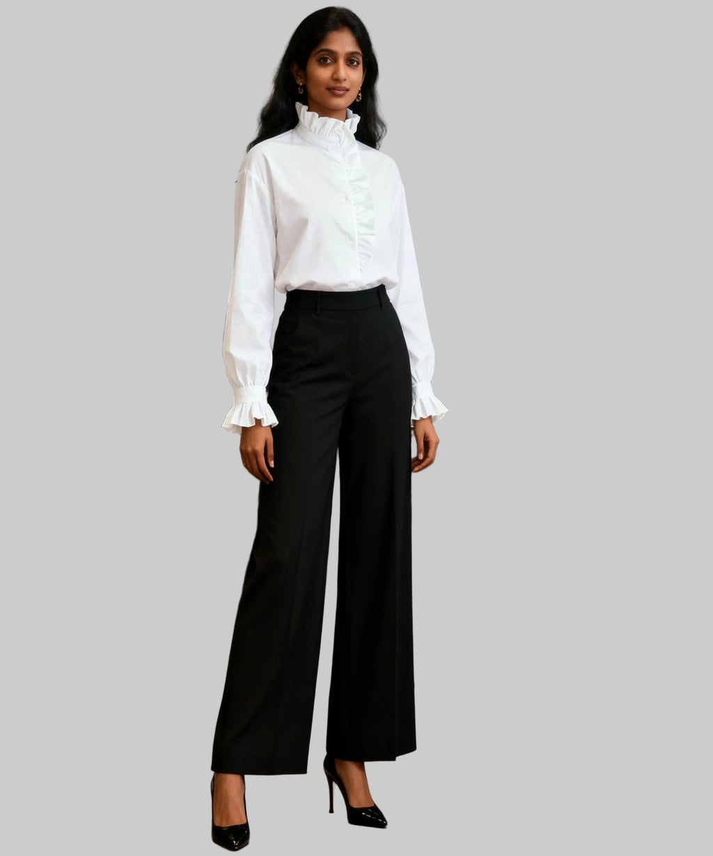 Woman in a white blouse and black pants standing in a white background