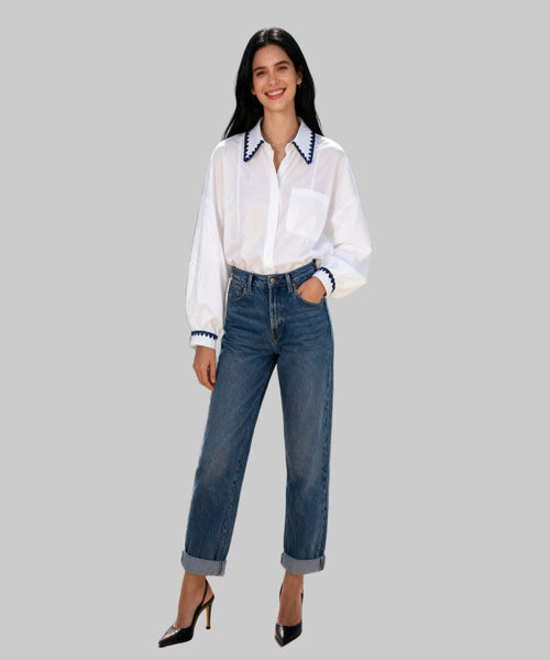 Woman in white blouse and blue jeans standing  in white background