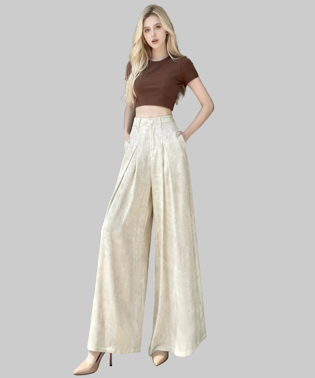 women wearing brown top and white trousers sitting on a white background