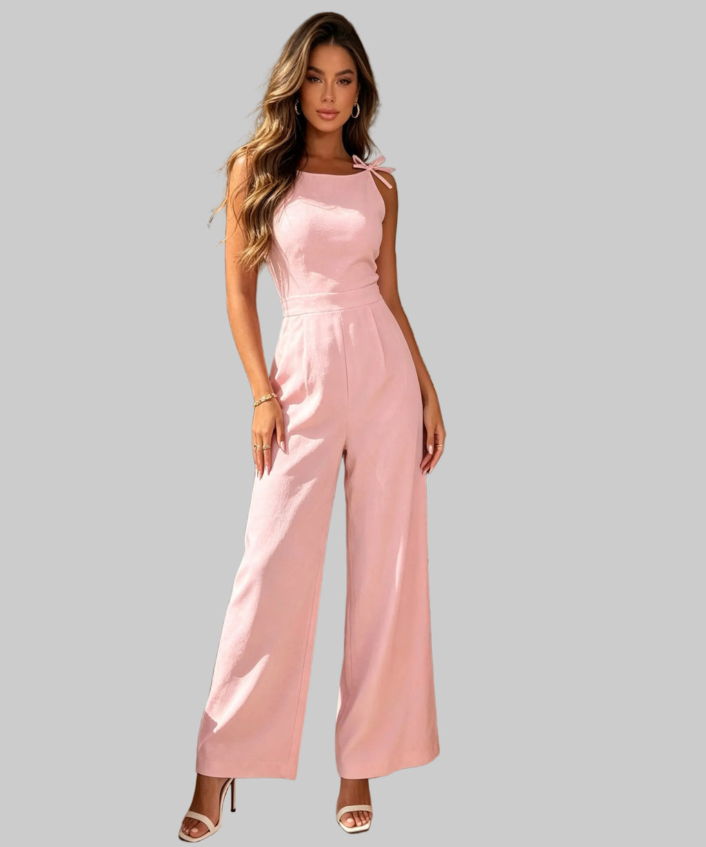 Woman in a pink jumpsuit surrounded by pink flowers in a white background.