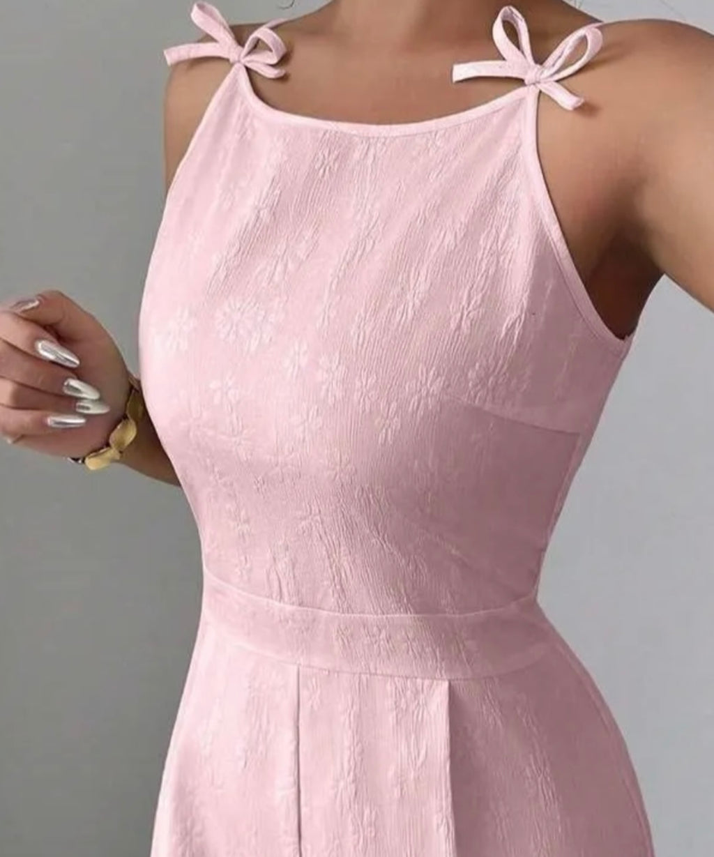 Pink dress with bow straps on a gray background