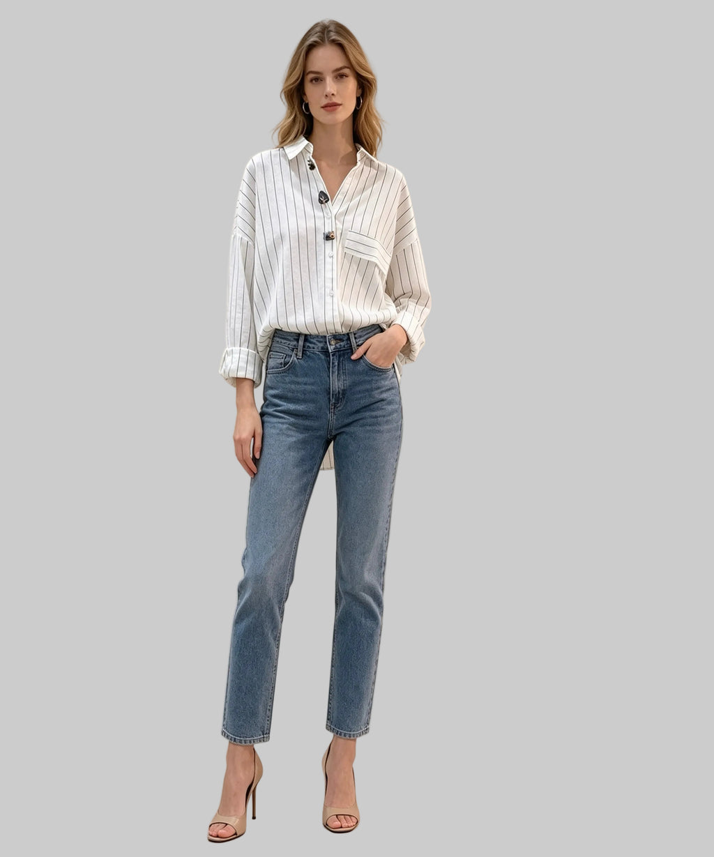 Woman wearing a striped shirt and blue jeans against a beige background