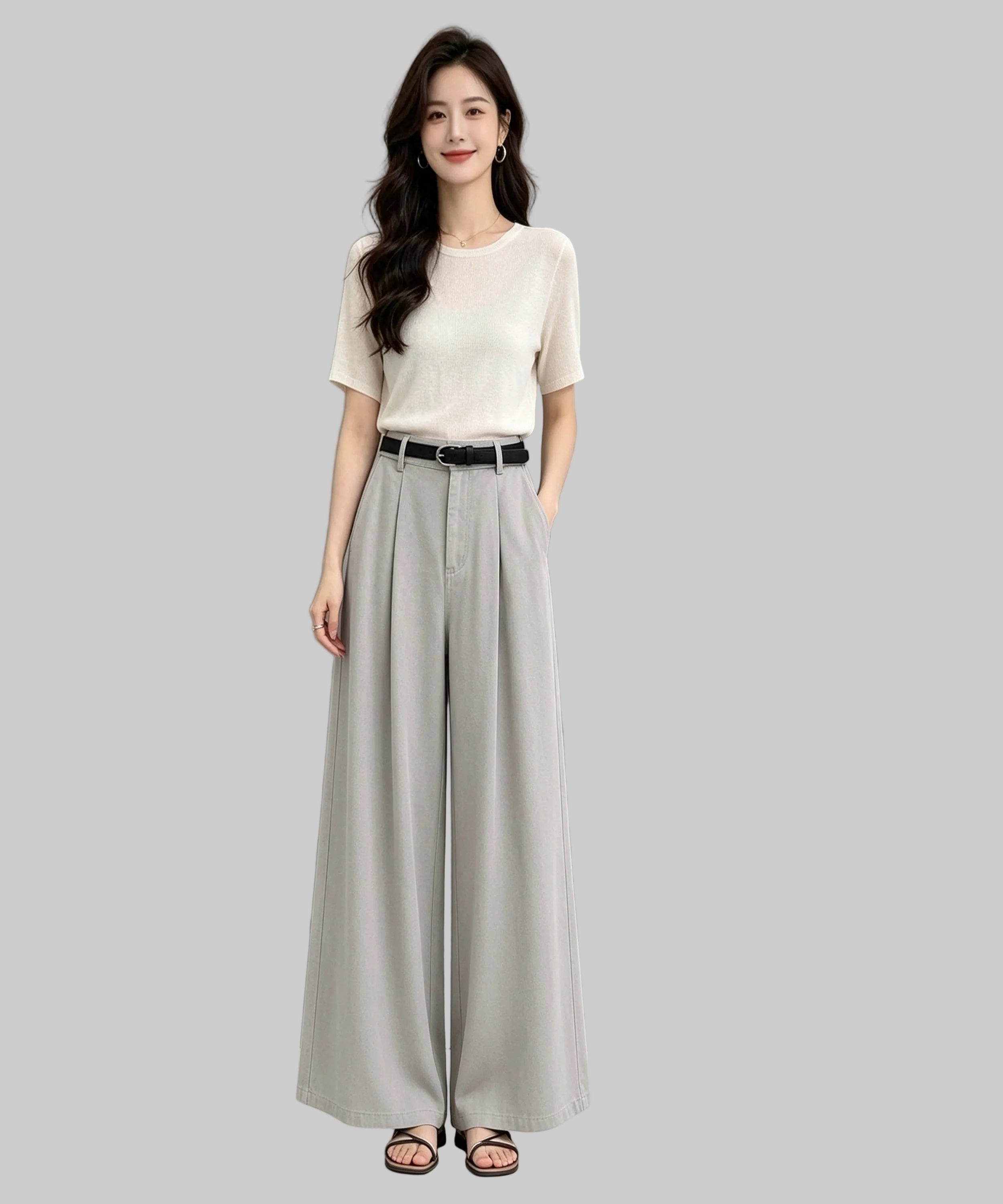 Woman wearing a white top and grey wide-leg pants on a white background
