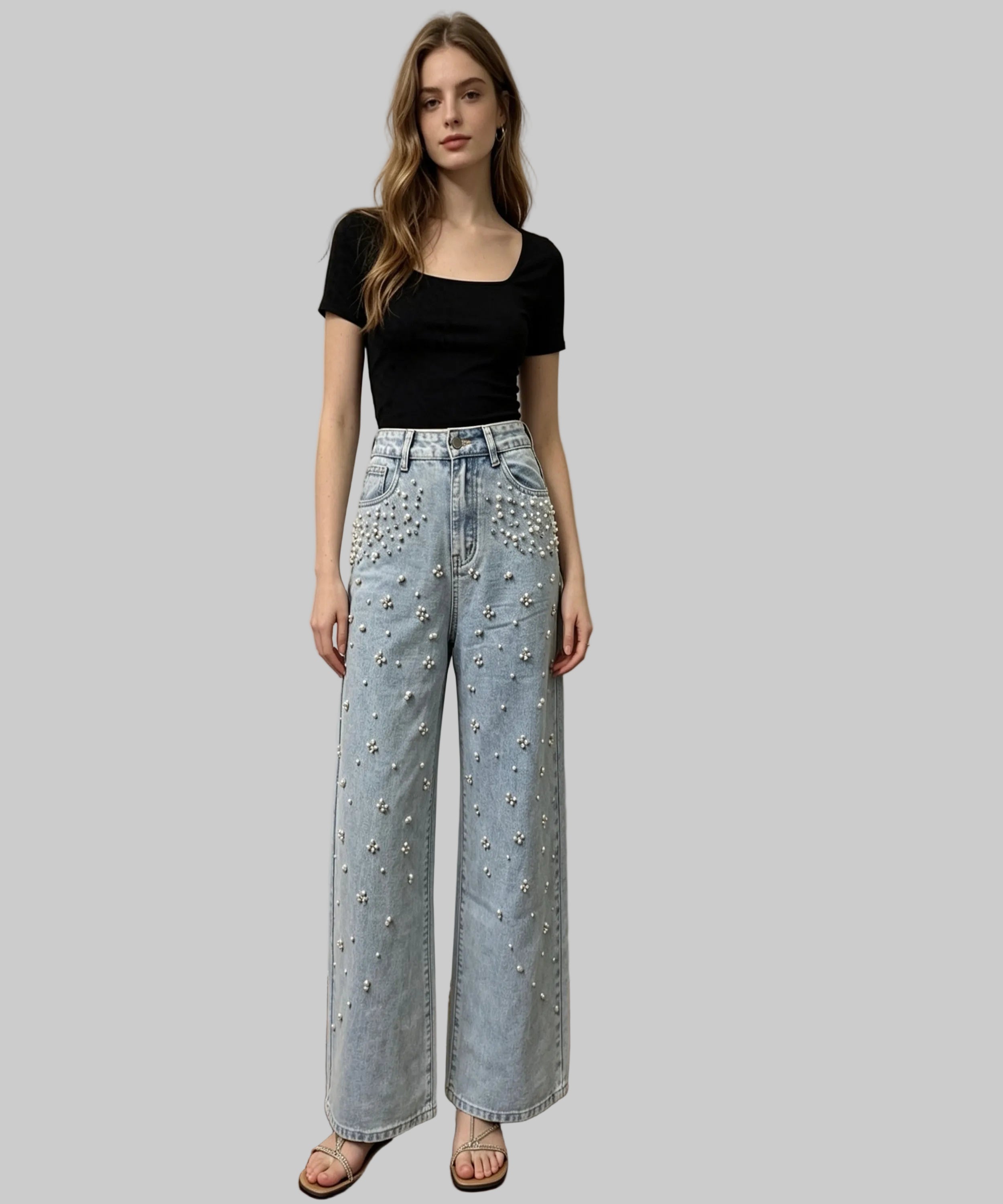 Woman wearing a black top and light blue jeans with decorative elements on a white background