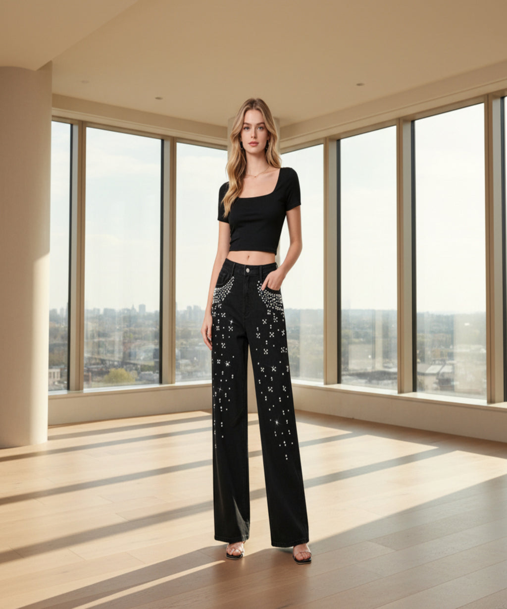 Woman wearing black embellished pants and black top in a living room