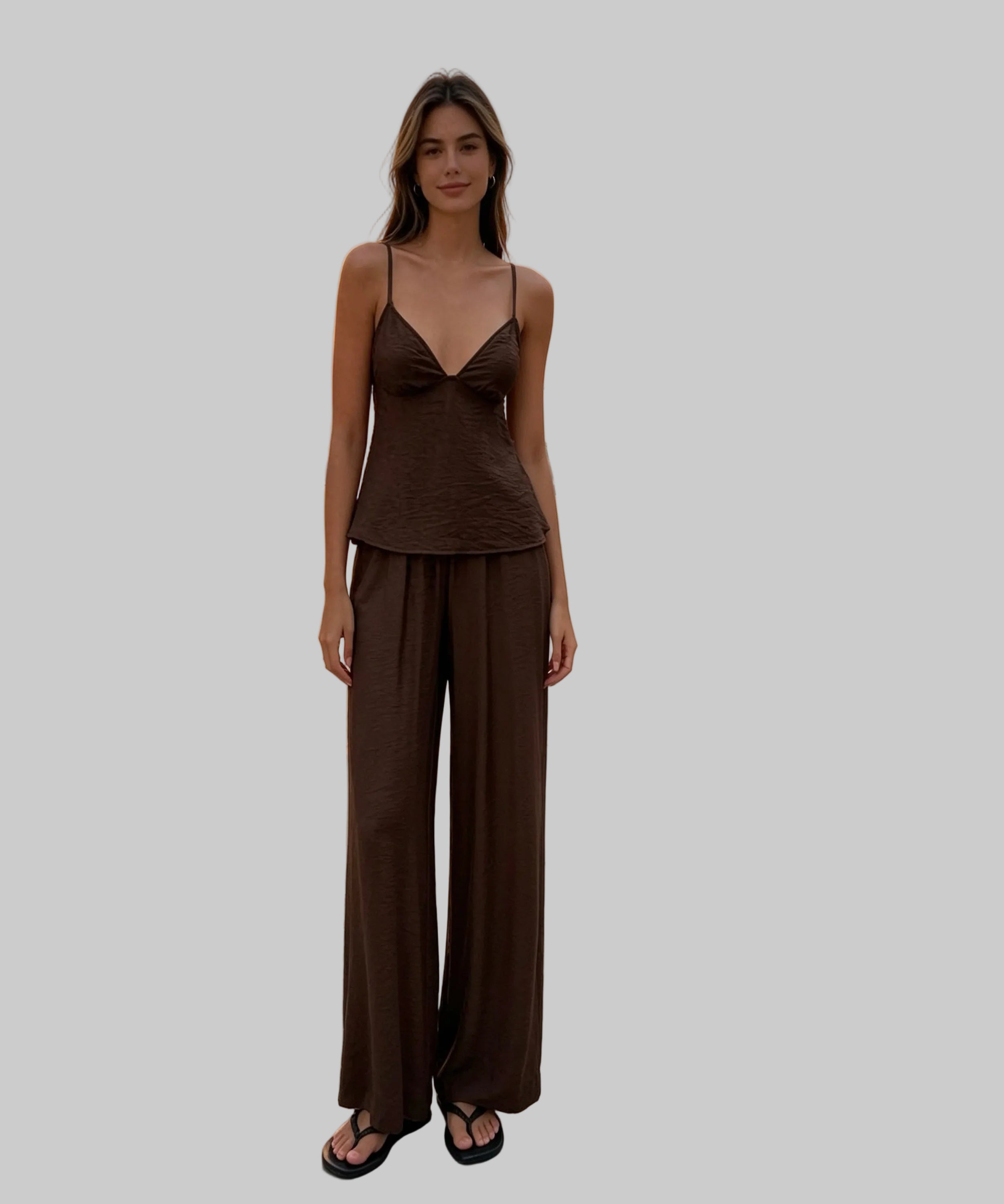 Woman in a brown outfit standing on a white  background