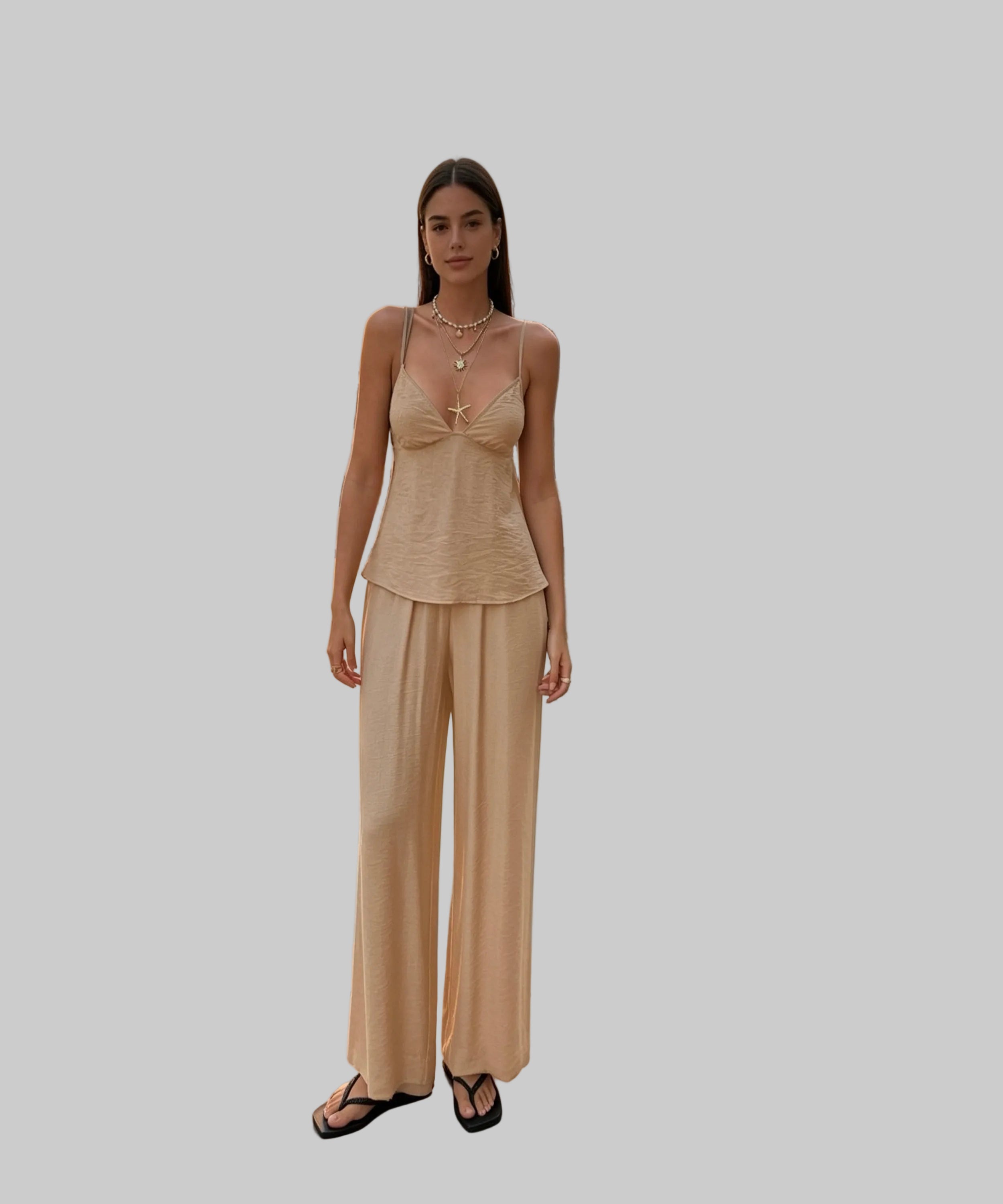 Woman in a beige outfit standing on a white background