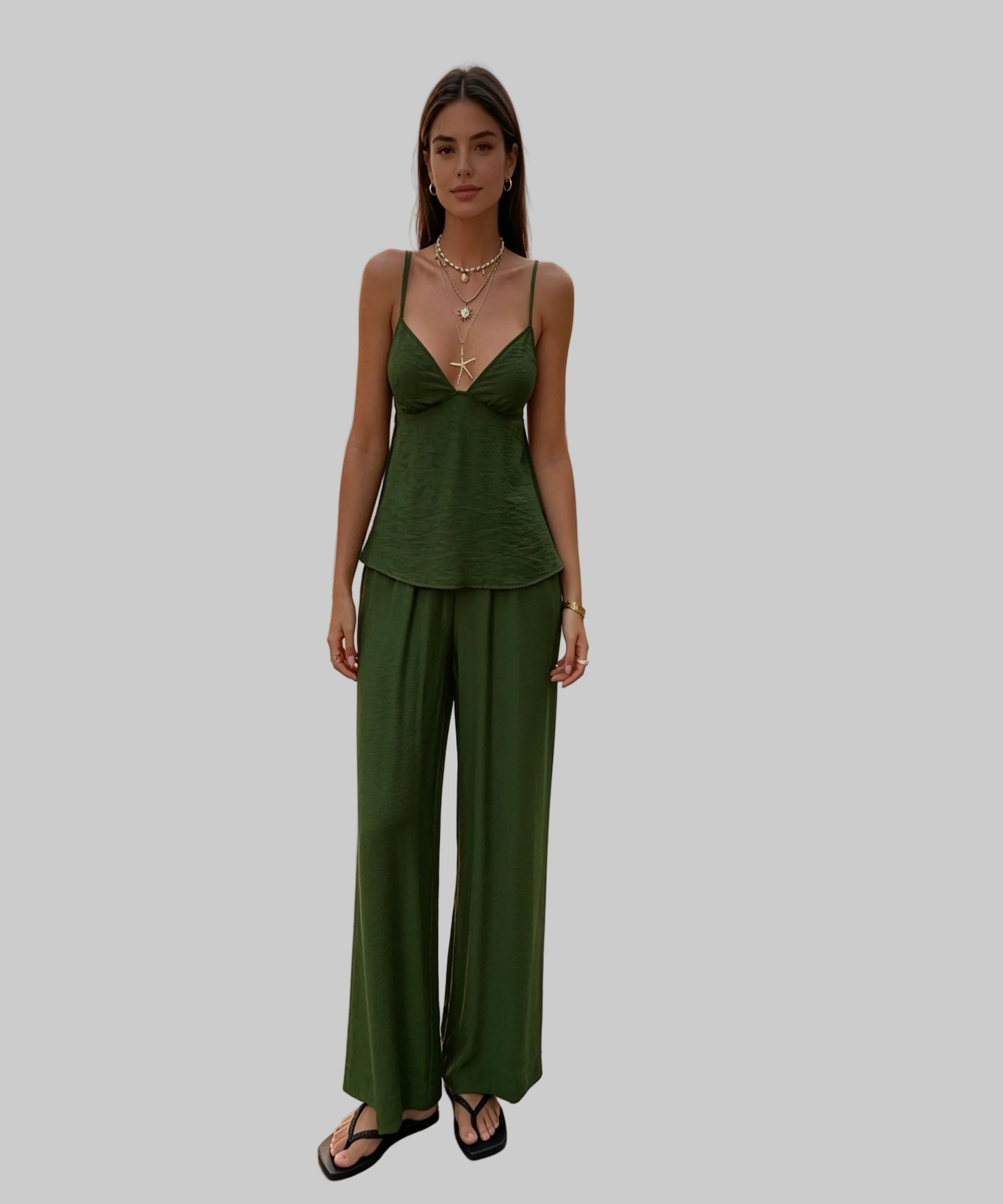 Woman in a green outfit standing on a white background