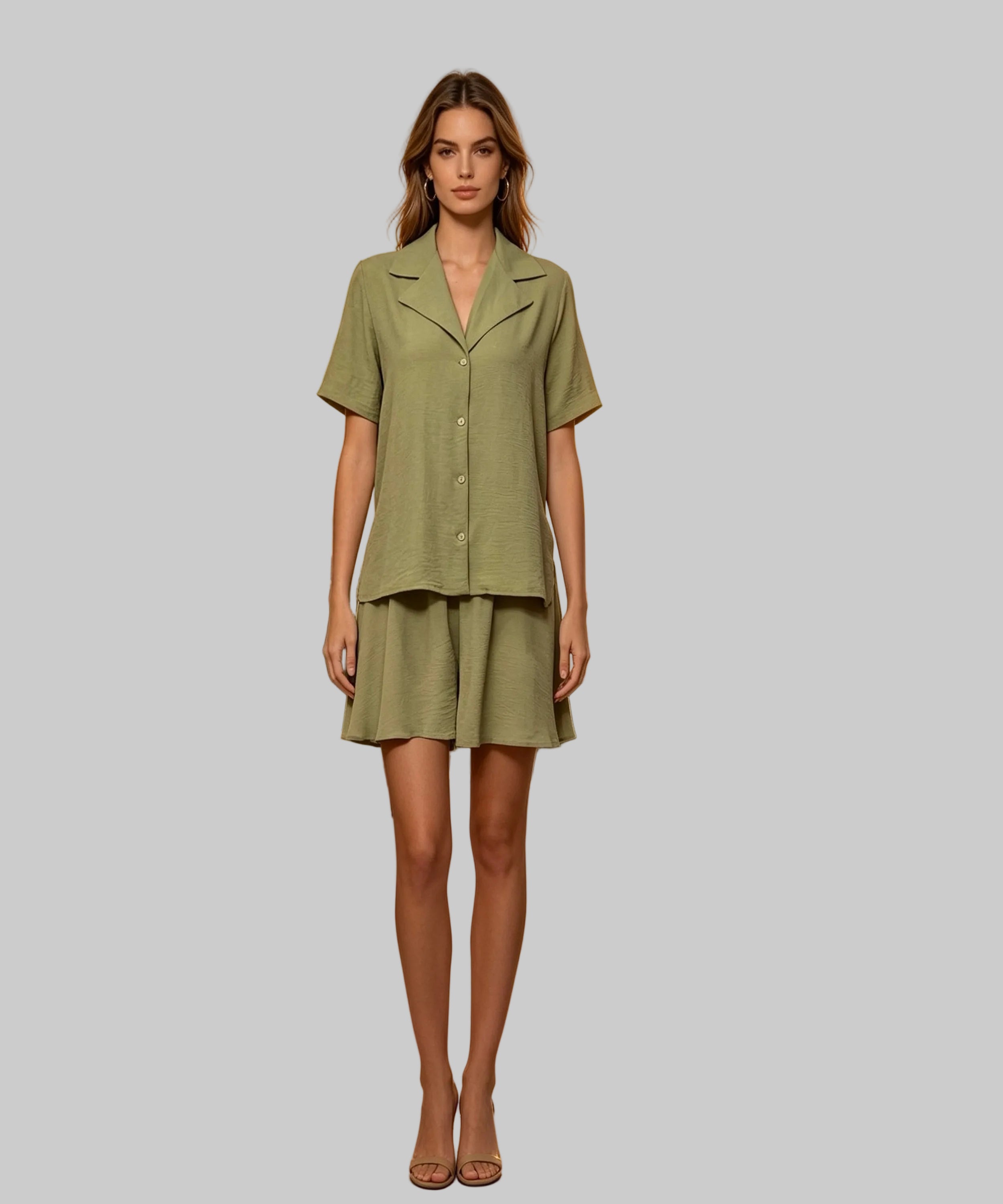 Woman in a green outfit standing on a white background.