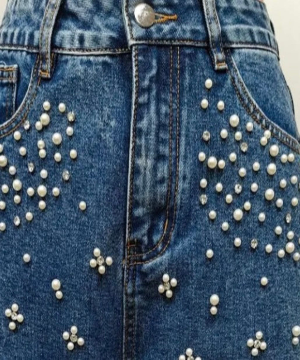 Blue denim jacket with pearl embellishments on a plain background