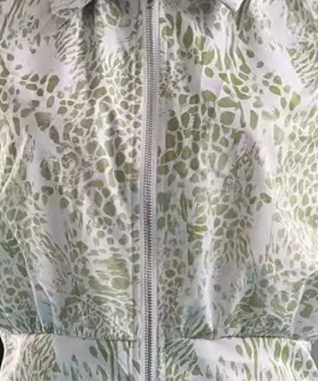 Close-up of a green and white patterned fabric with a zipper.