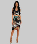 Woman wearing a black dress with colourful floral patterns on a white background.