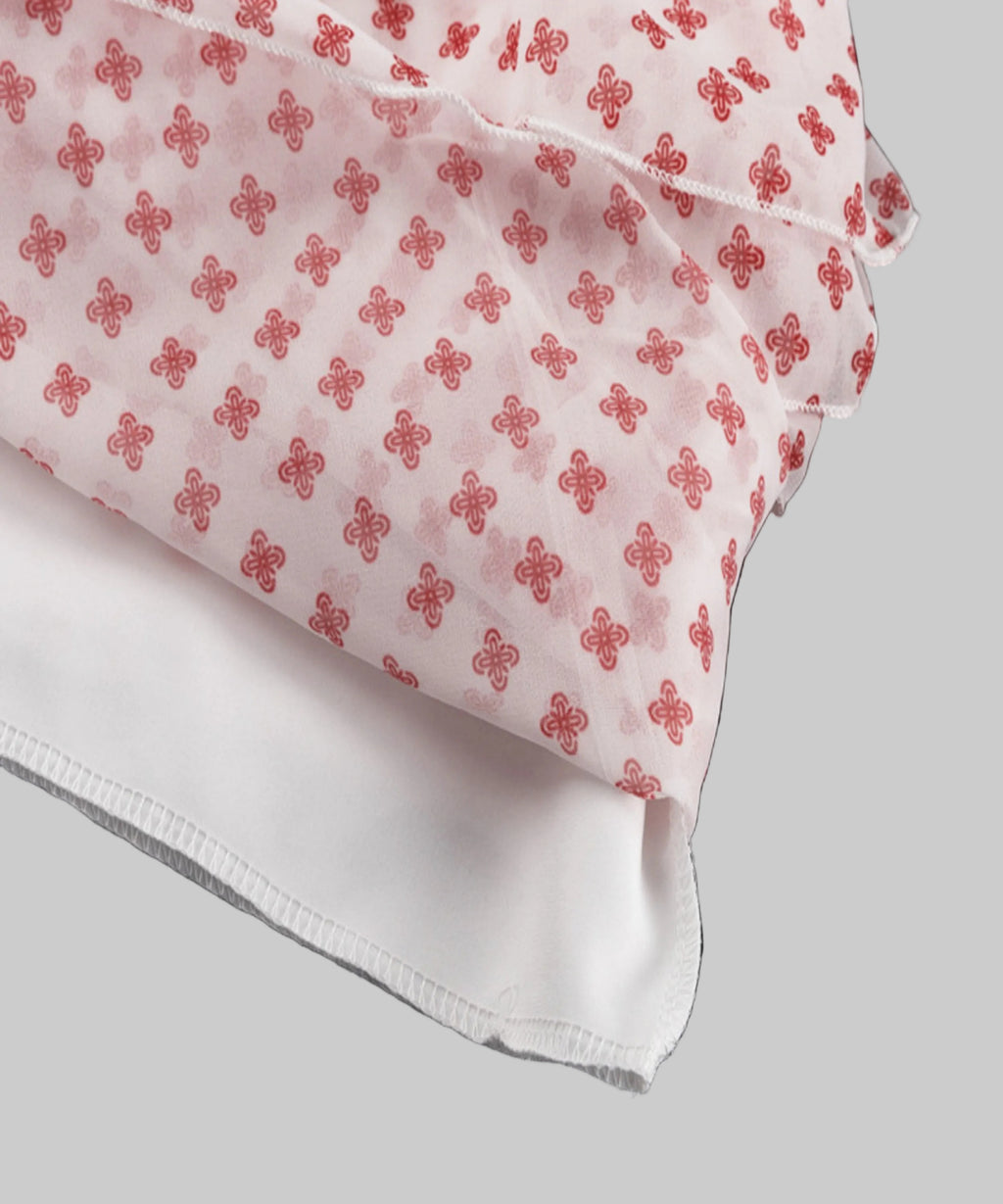 White fabric with red floral pattern on a white background