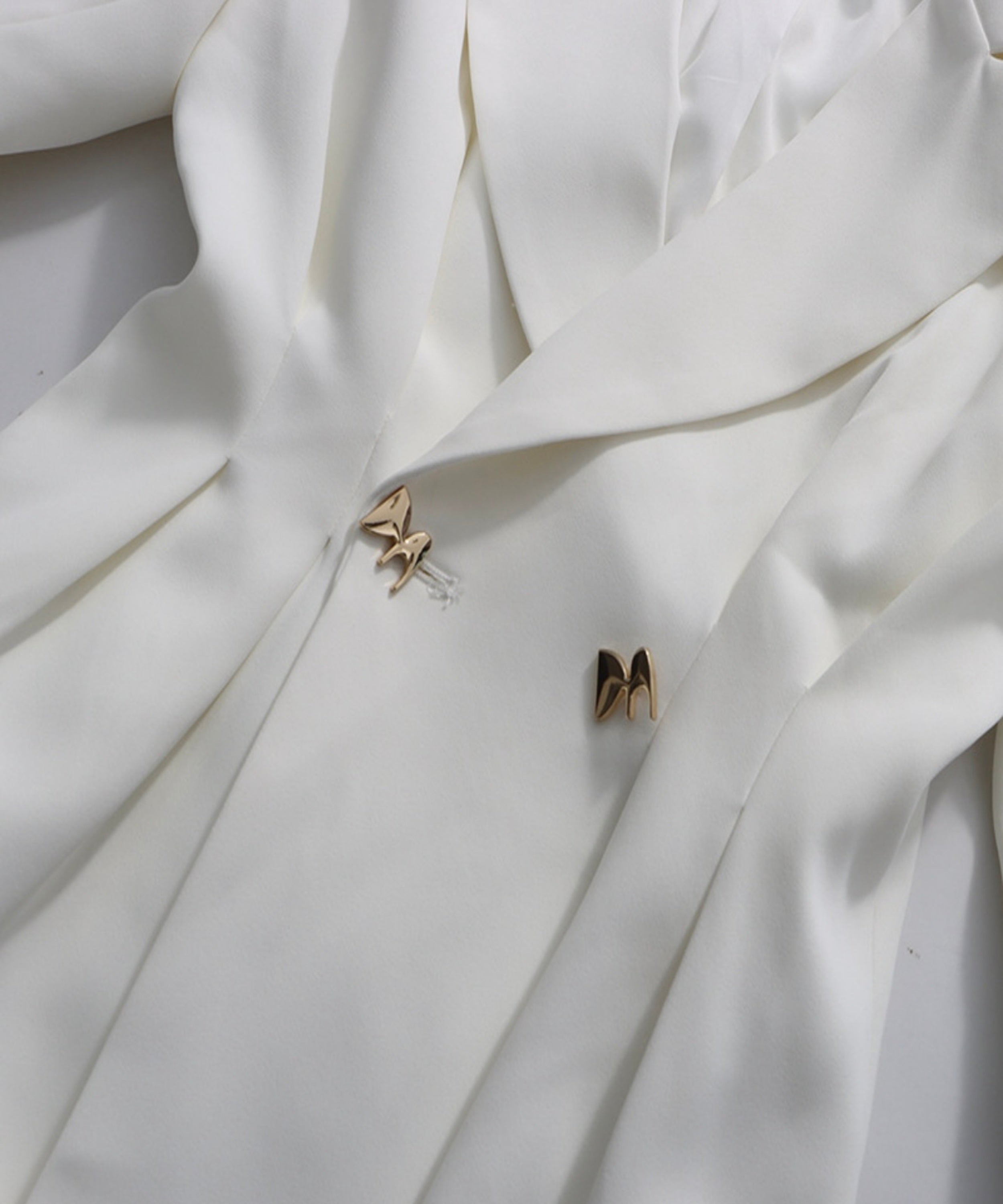 Butterfly-shaped earrings on a white fabric background
