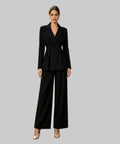 Woman in a black suit standing on a white background
