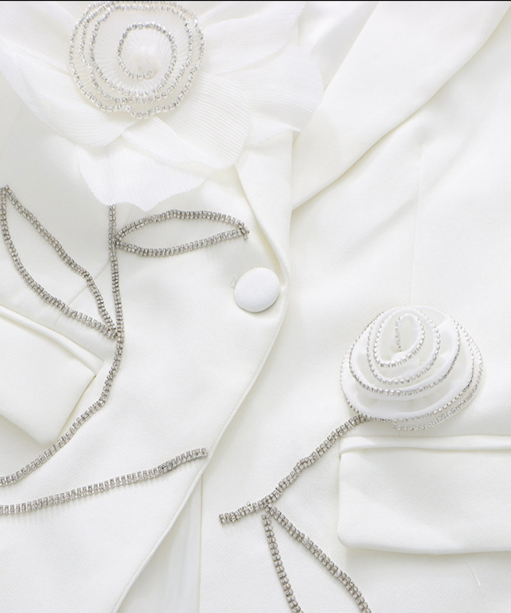 White blazer with decorative buttons and jewelry on a white background