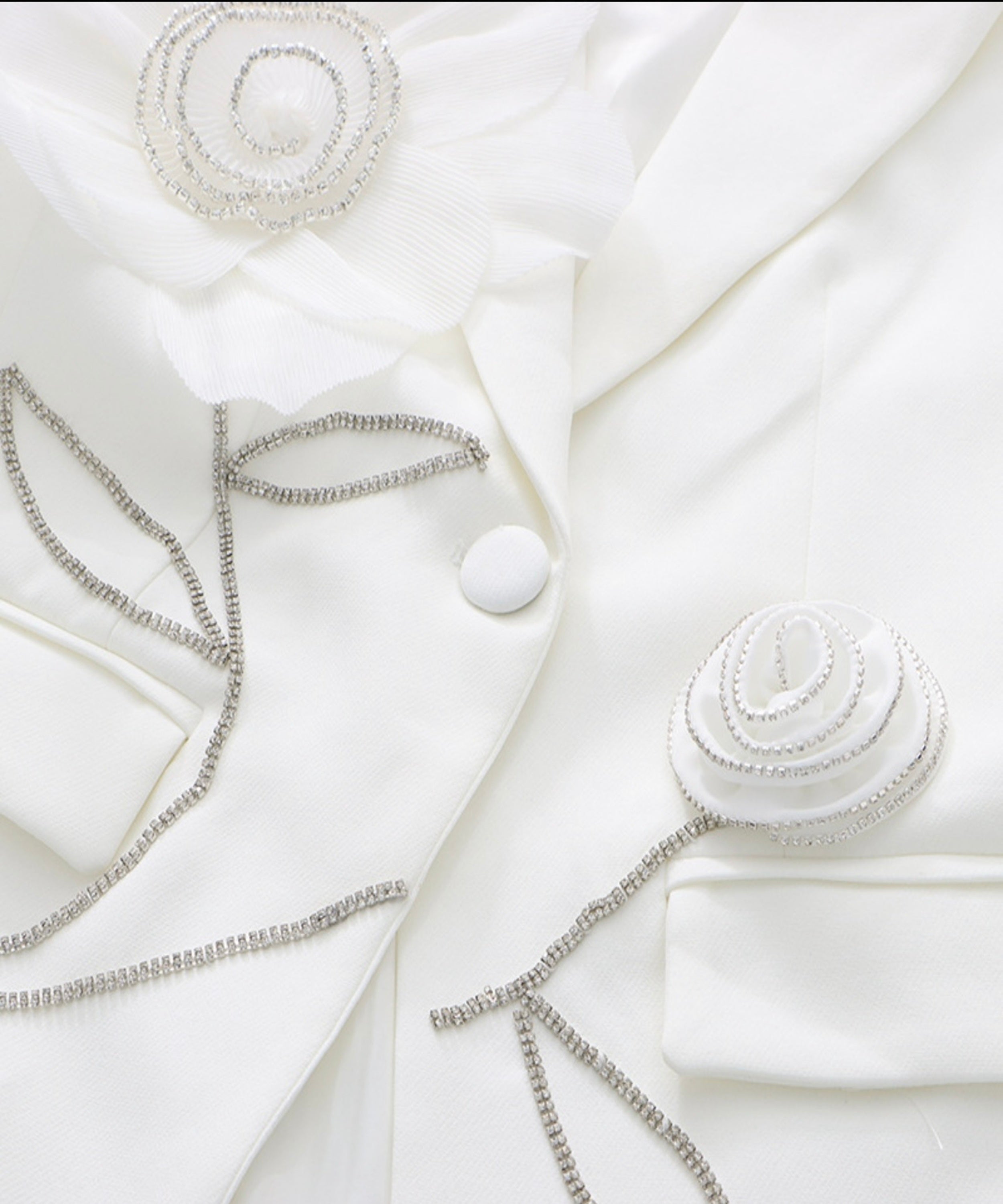 White blazer with decorative buttons and jewelry on a white background