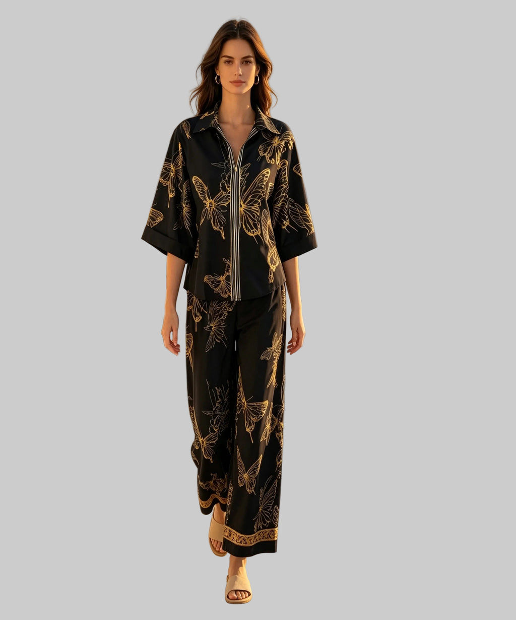 Woman in a black and gold outfit standing on a white background