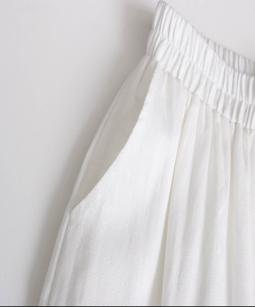 Close-up of a white textured fabric against a light gray background