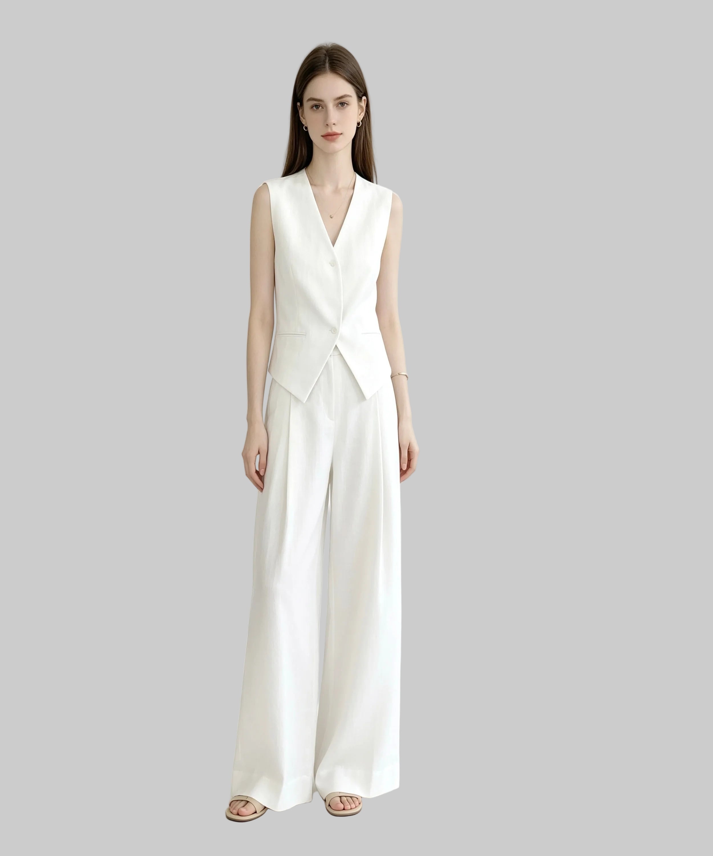 Woman wearing a white sleeveless jumpsuit on a plain background