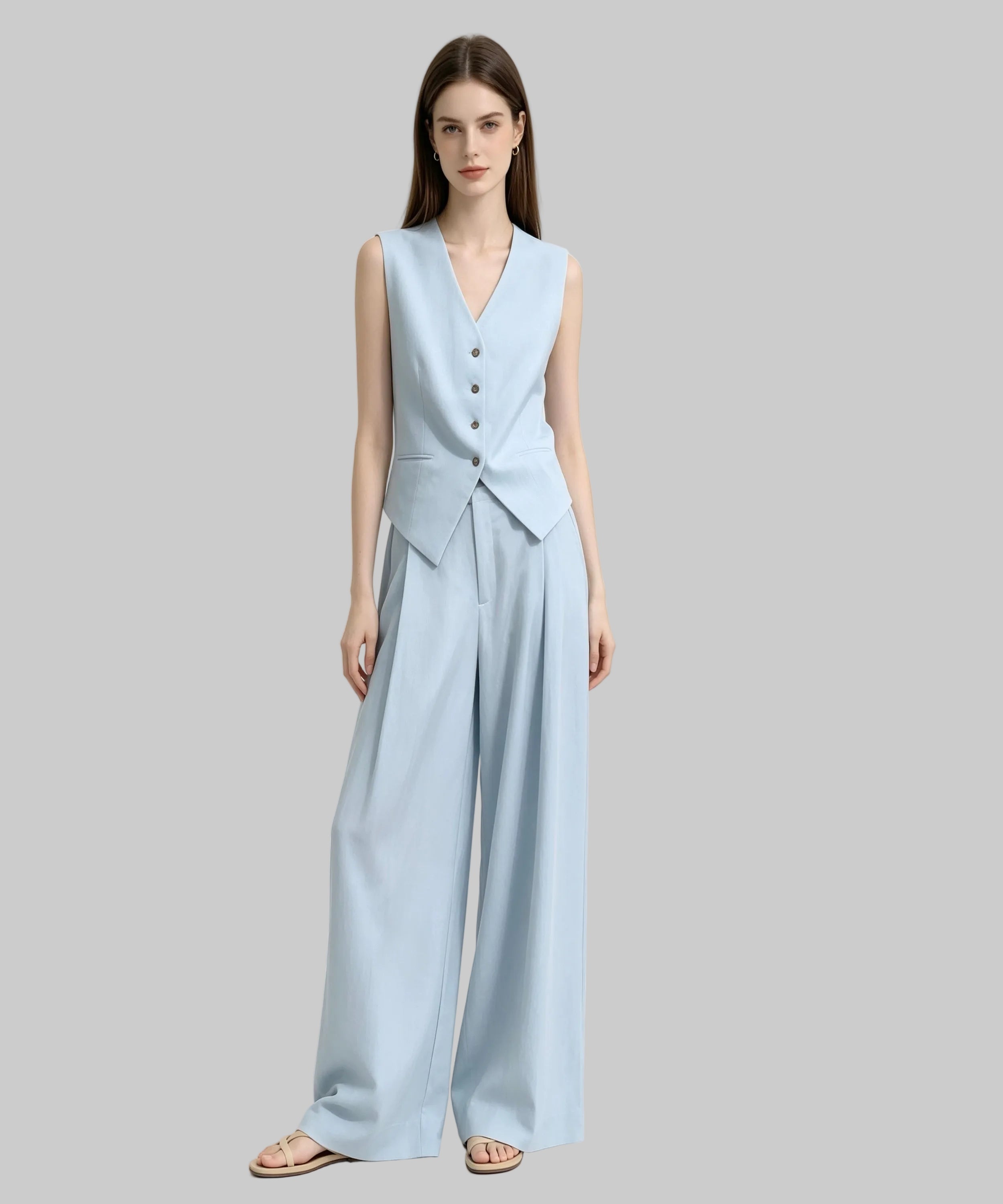 Woman wearing a light blue sleeveless jumpsuit on a white background