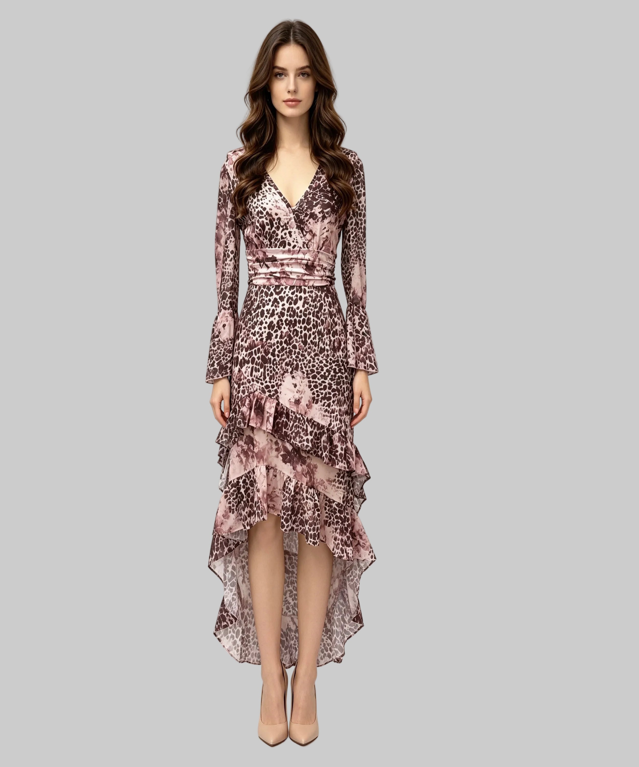 A woman modeling a long-sleeve high-low dress with a pink, brown, and black leopard print and floral overlay, set against a plain light gray background.