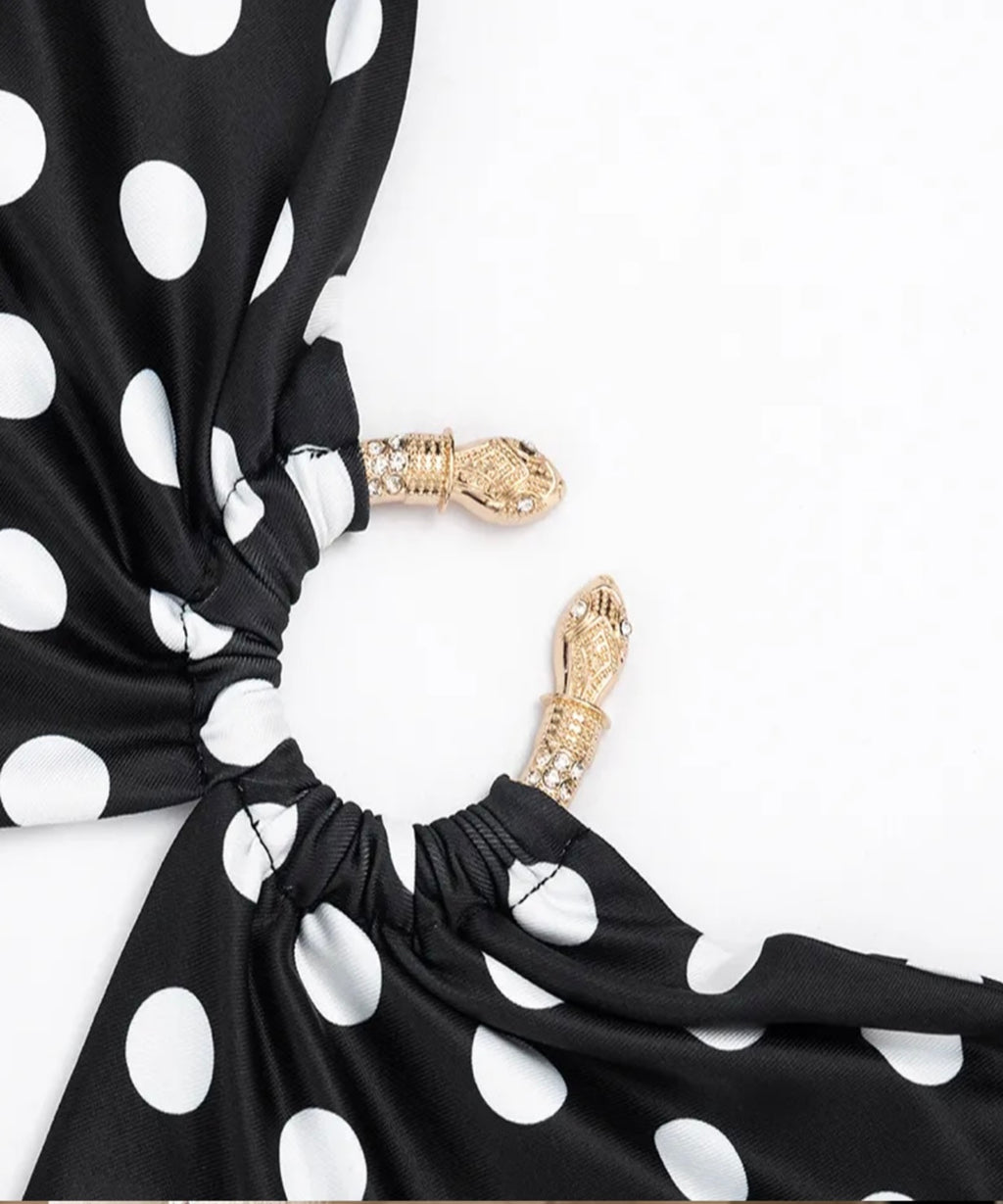 Black and white polka dot fabric accessory with gathered elastic sections and decorative gold-toned hardware, photographed on a plain white background.