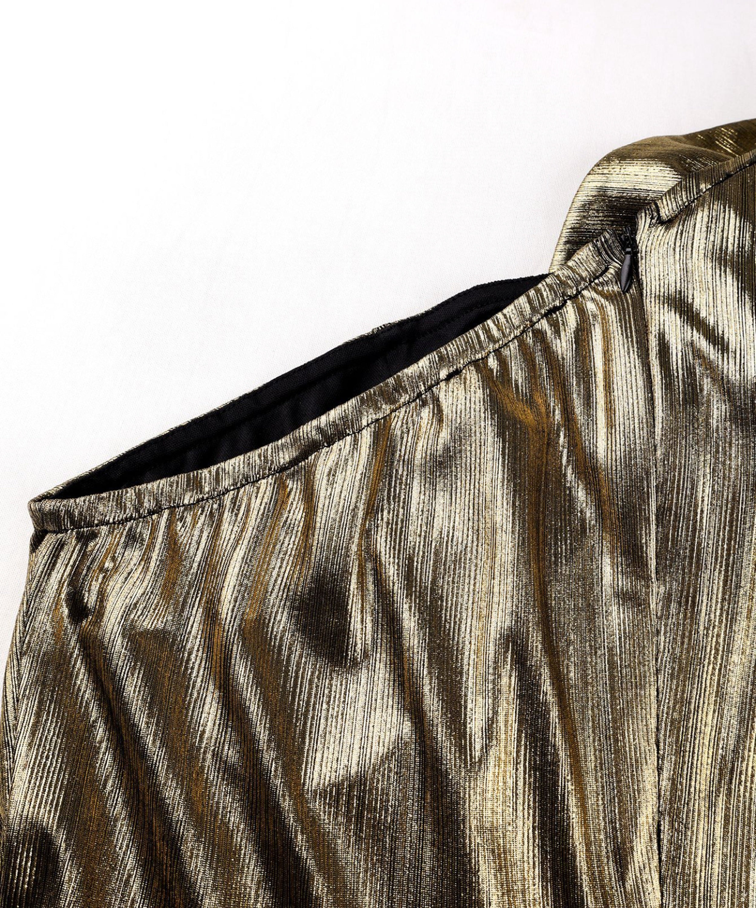 Close-up of a metallic gold and black outfit with a white background