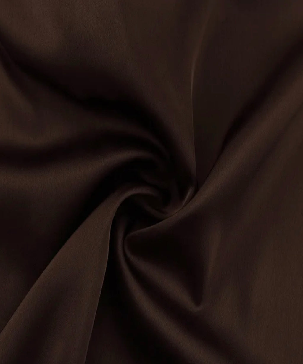 A close-up of dark brown fabric with soft folds and a smooth texture.