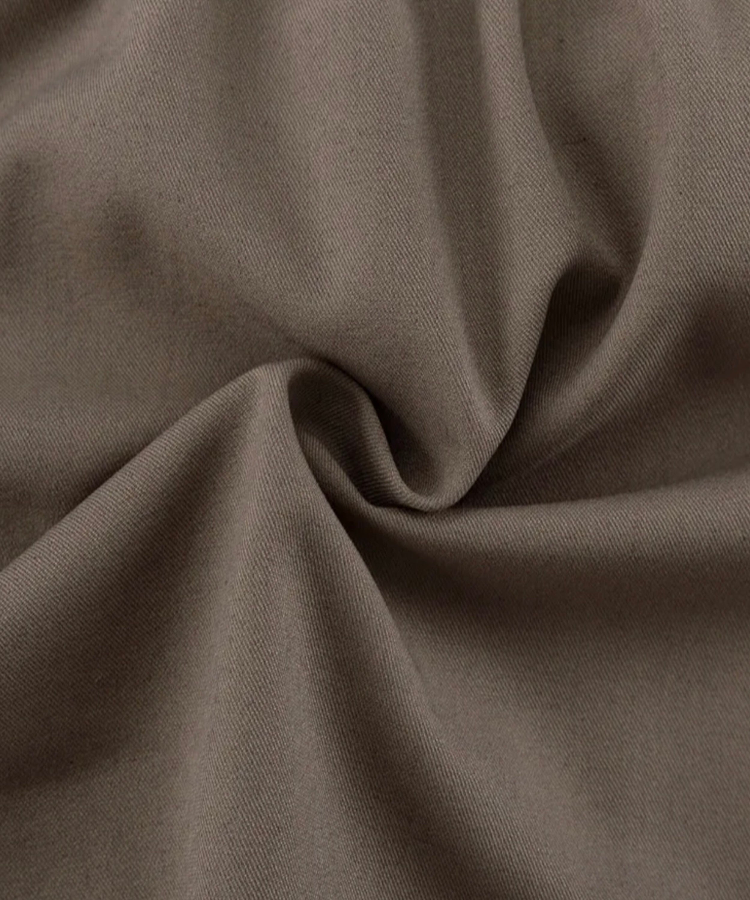 A close-up of draped fabric in a muted taupe-brown color, showing the material texture and soft folds.