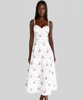 Woman wearing a white floral dress on a gray background