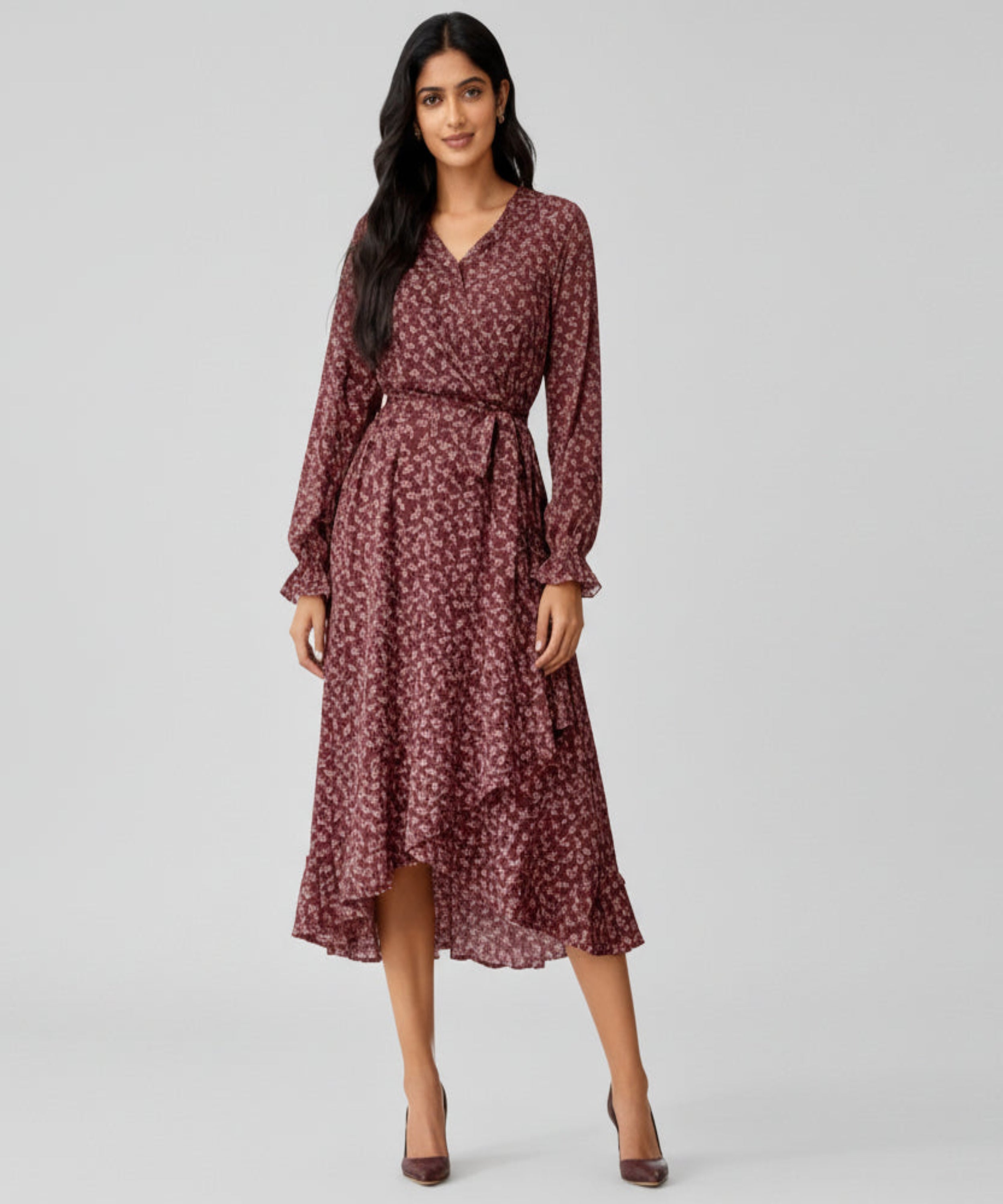 Woman wearing a maroon floral dress on a white background