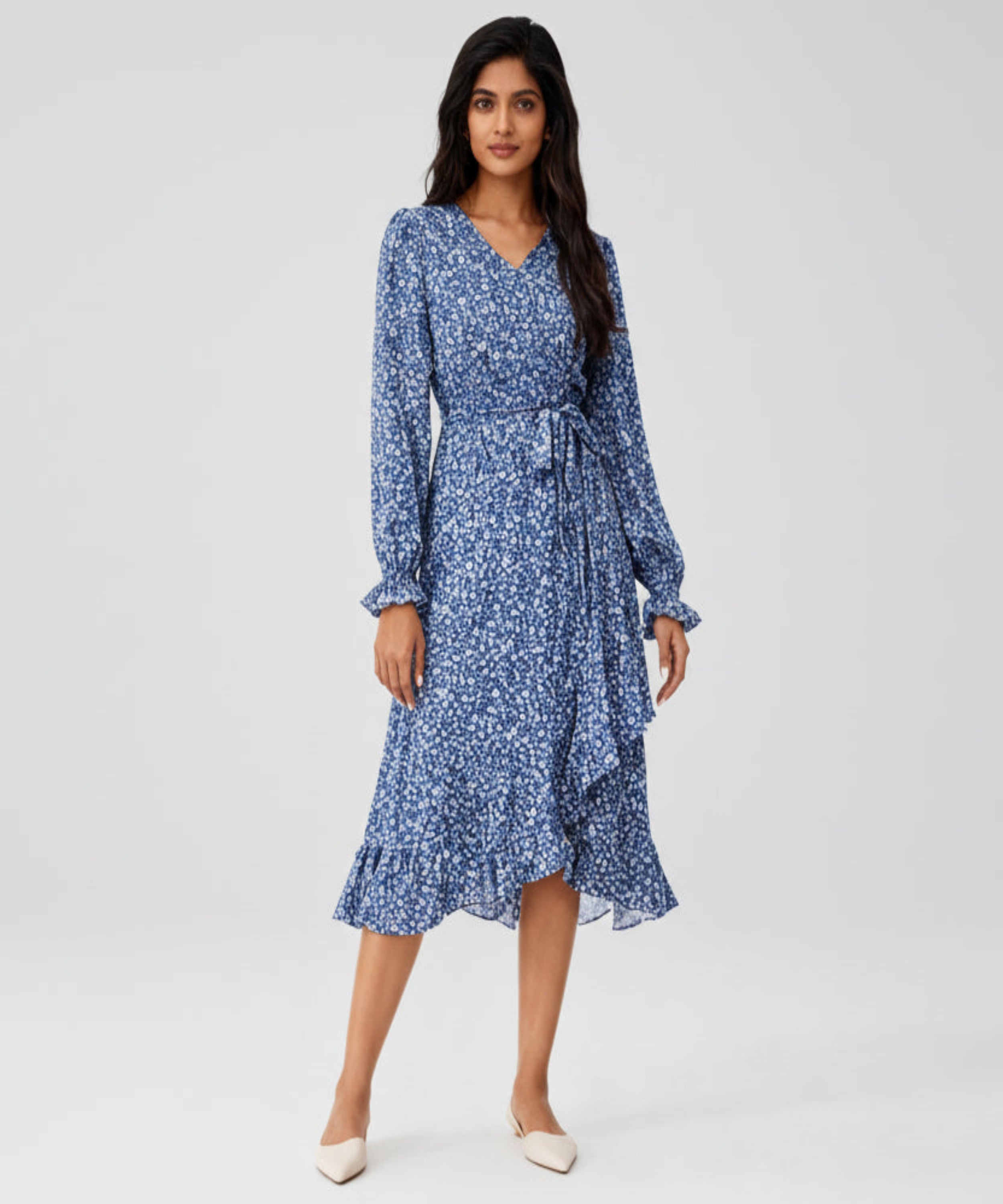 Woman wearing a blue floral dress on a white background