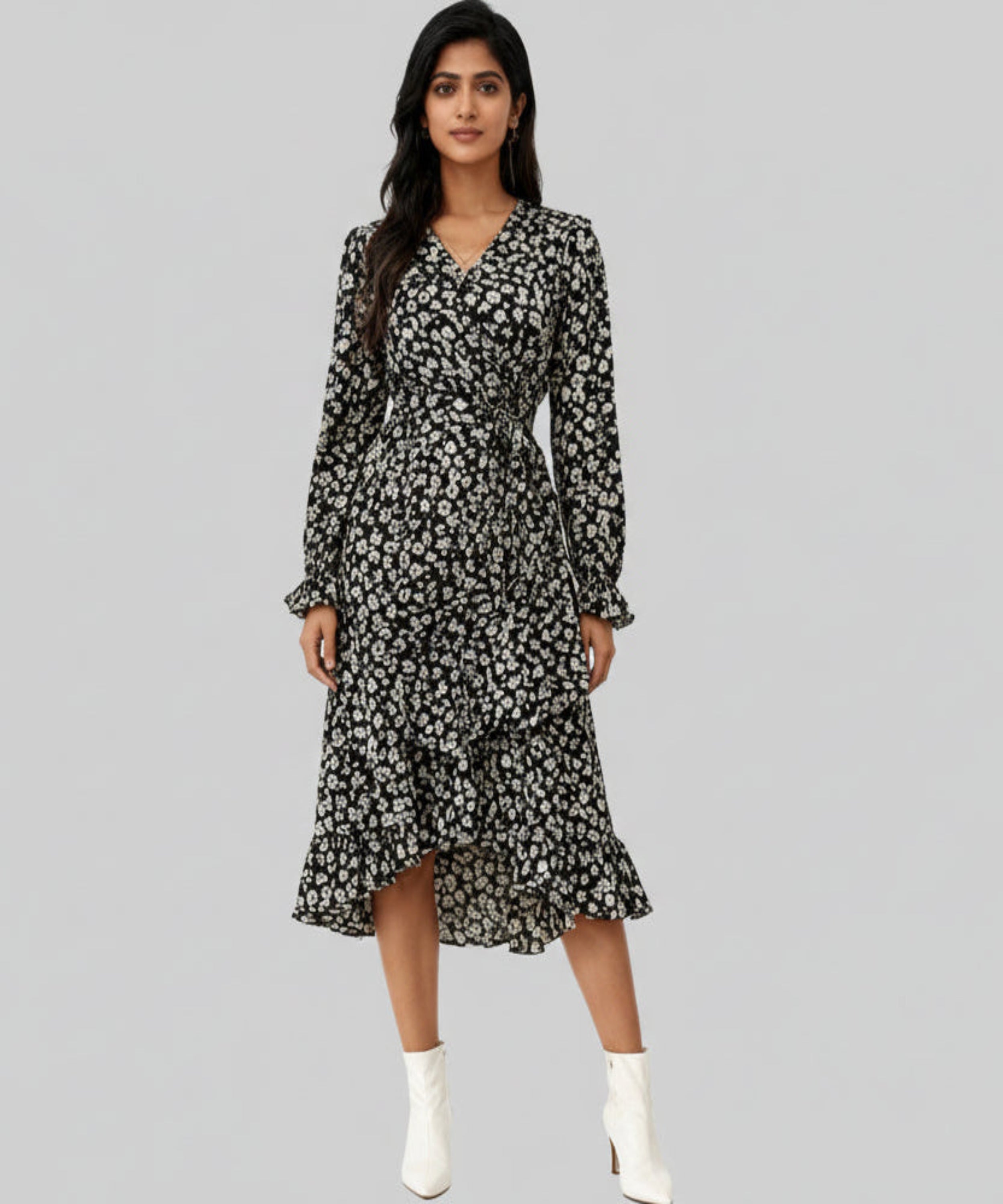 Woman wearing a black floral dress with white boots on a white background
